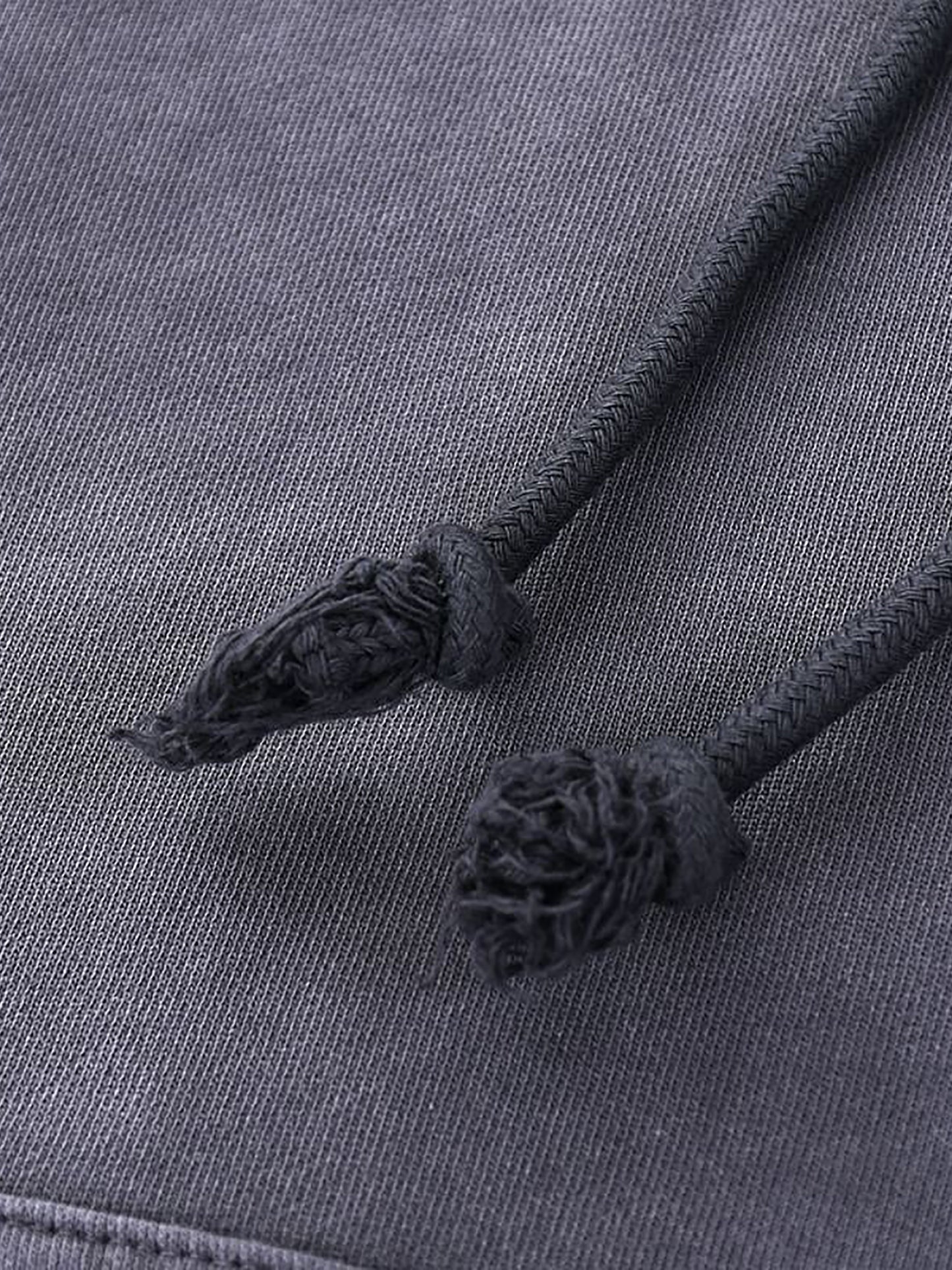 Close-up of a gray fabric with tassels on a matching gray background