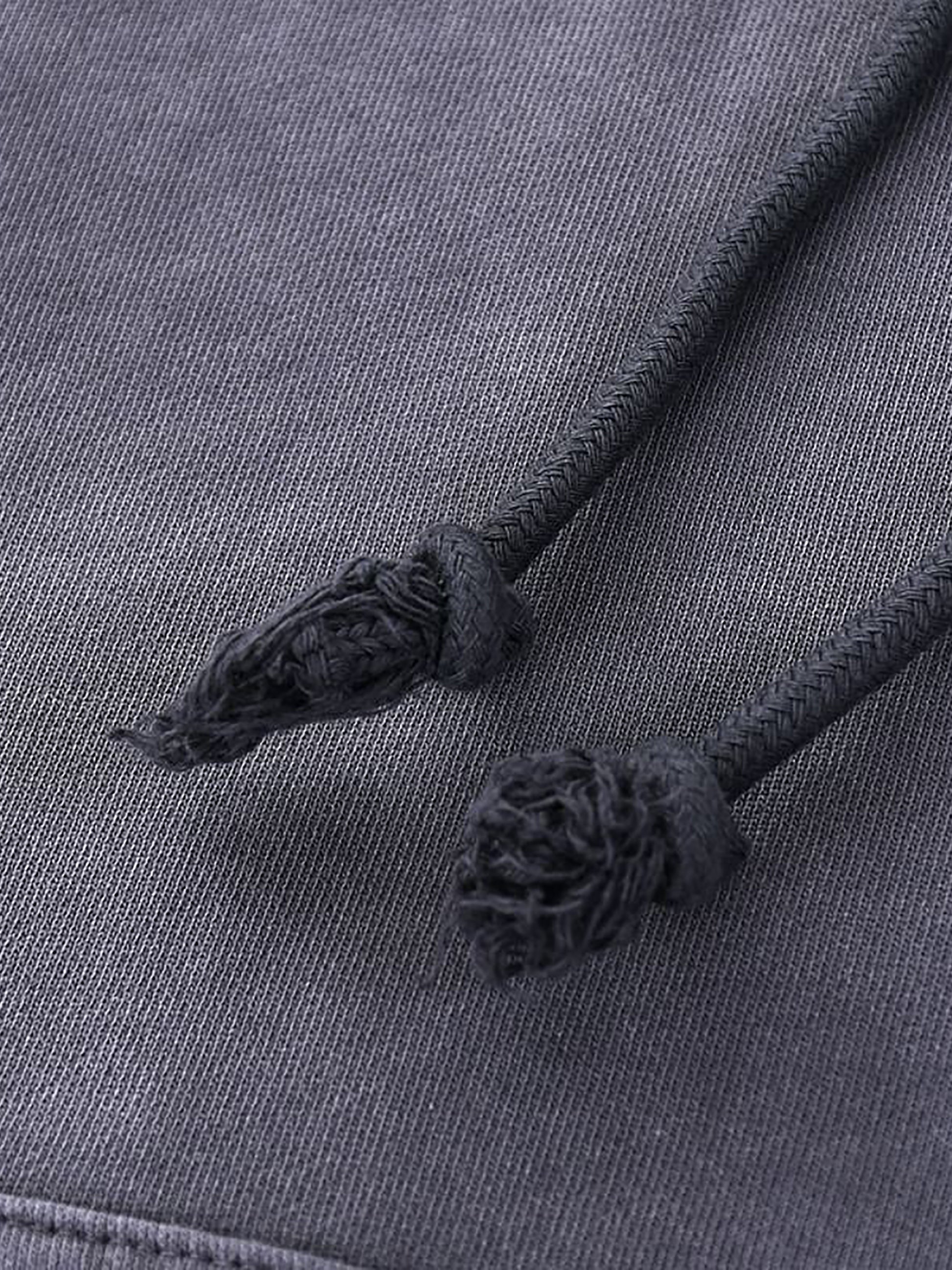 Close-up of a gray fabric with tassels on a matching gray background