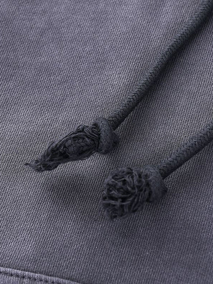 Close-up of a gray fabric with tassels on a matching gray background