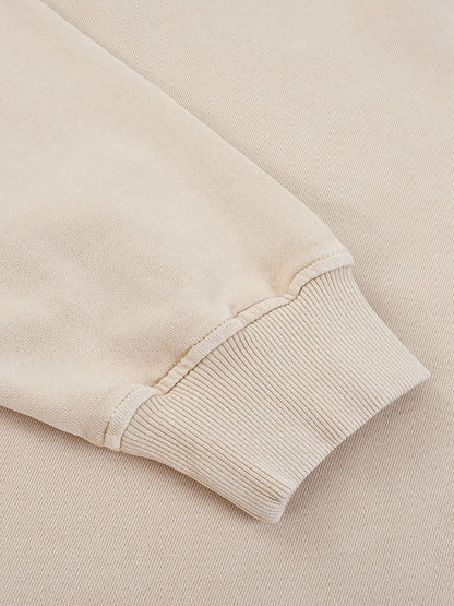 Close-up of a beige sweater sleeve on a matching background