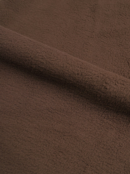 Close-up of brown fabric with a soft texture. 