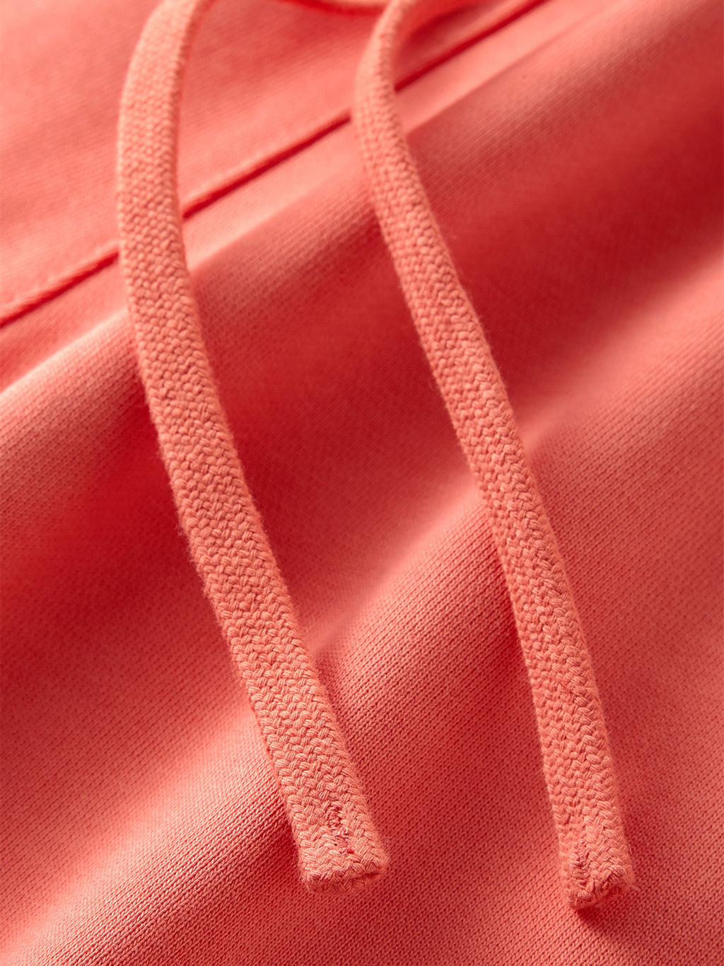 VERON Close-up of pink fabric with drawstrings on a matching pink background
