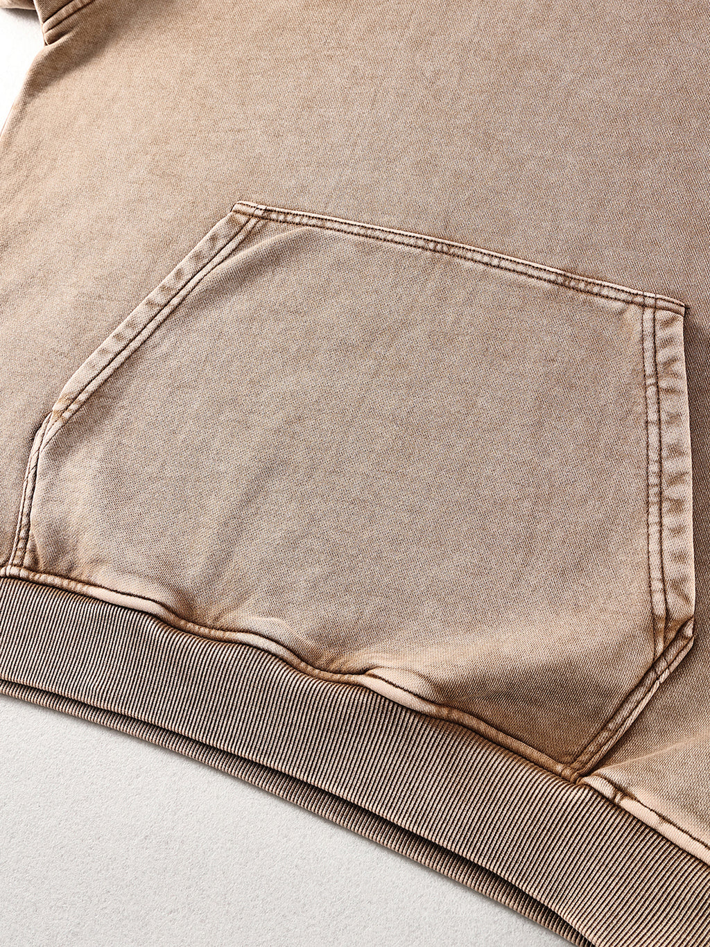 Close-up of a brown denim pocket on a garment.