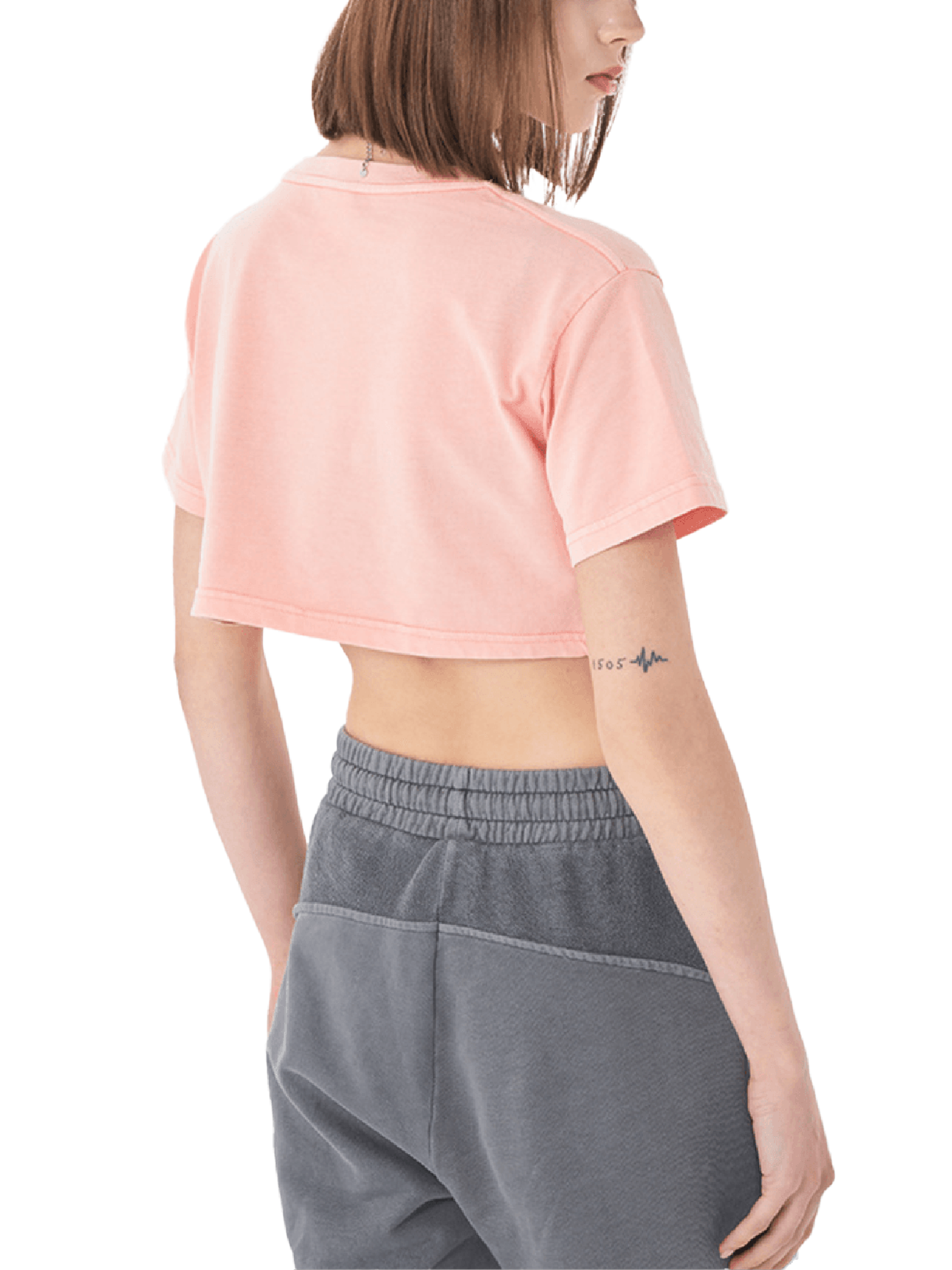 Person wearing a pink cropped t-shirt and gray pants on a white background