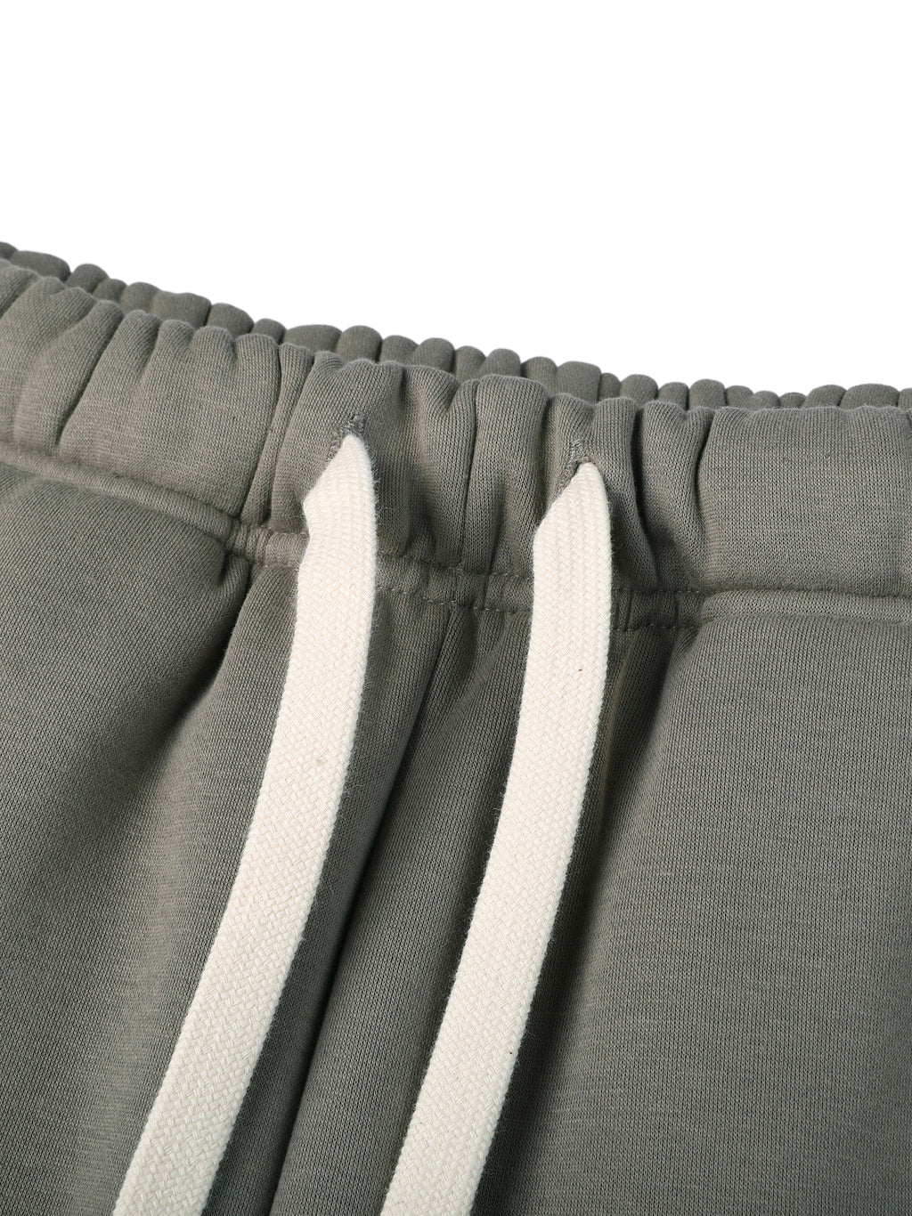 Close-up of gray sweatpants with white drawstrings on a white background