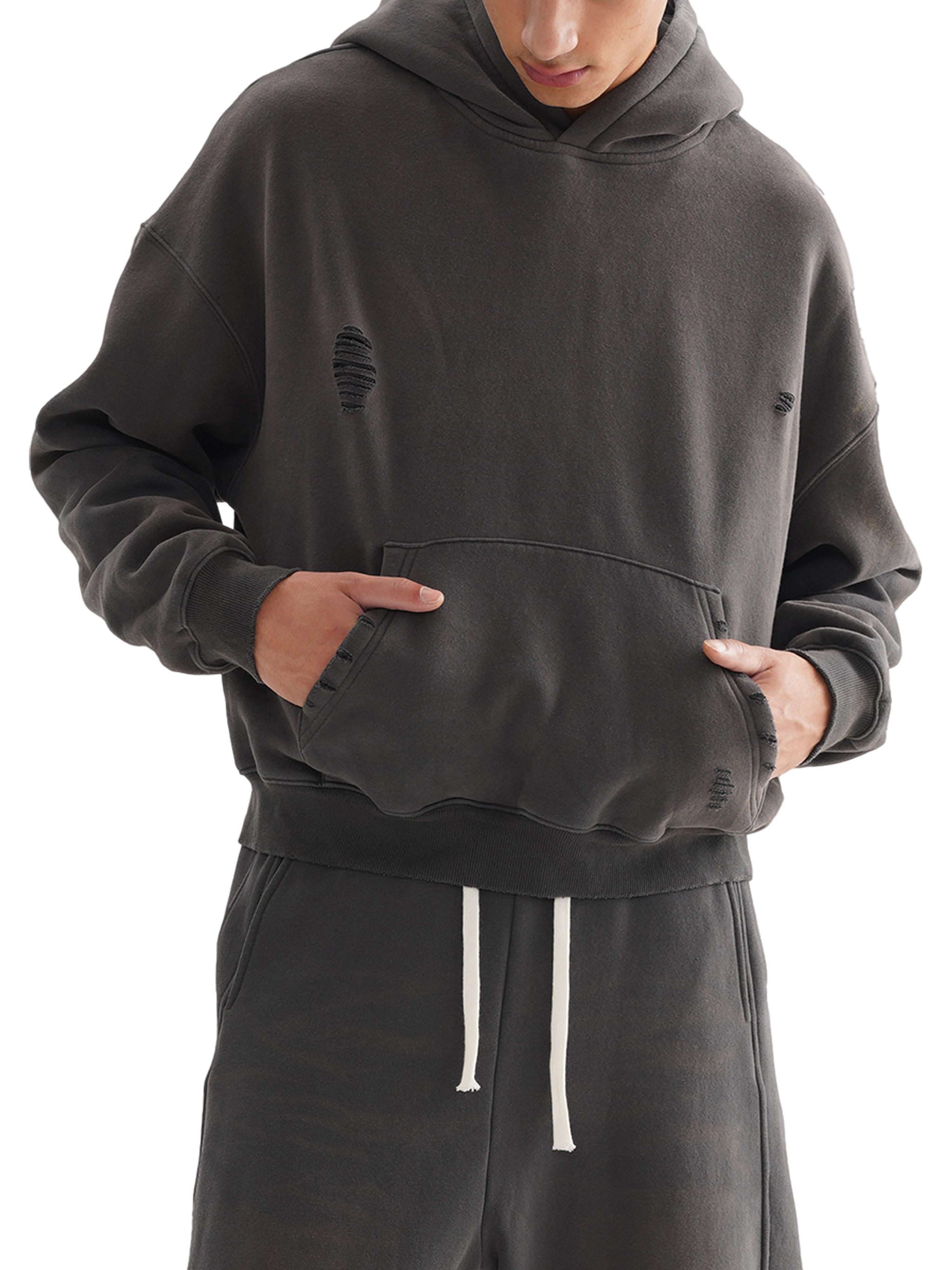 Person wearing a dark gray hoodie and matching pants on a white background