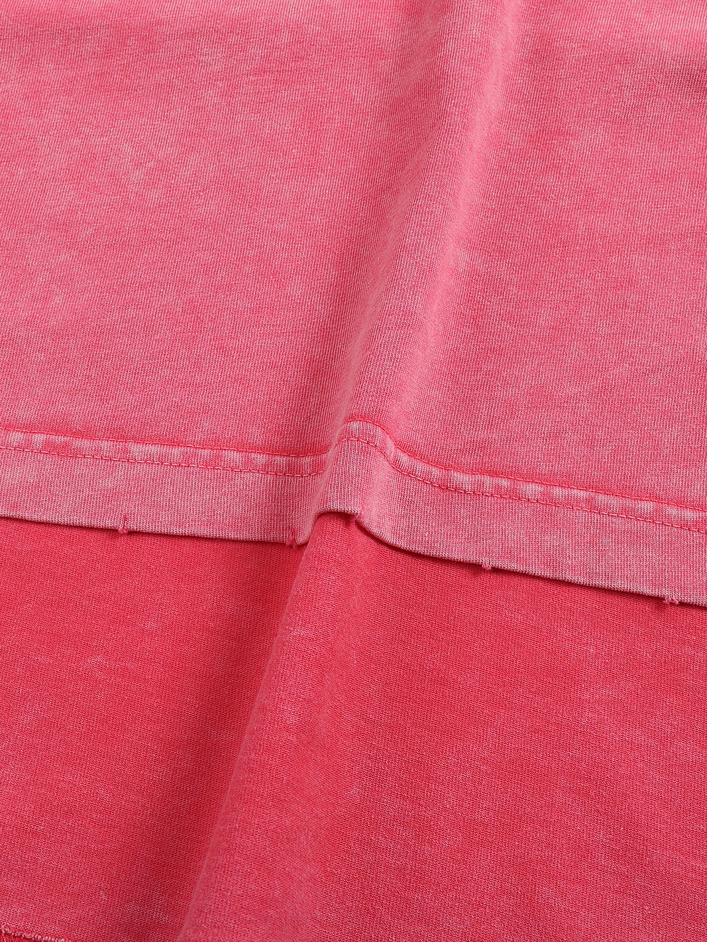 Close-up of pink fabric with a focus on texture and stitching.