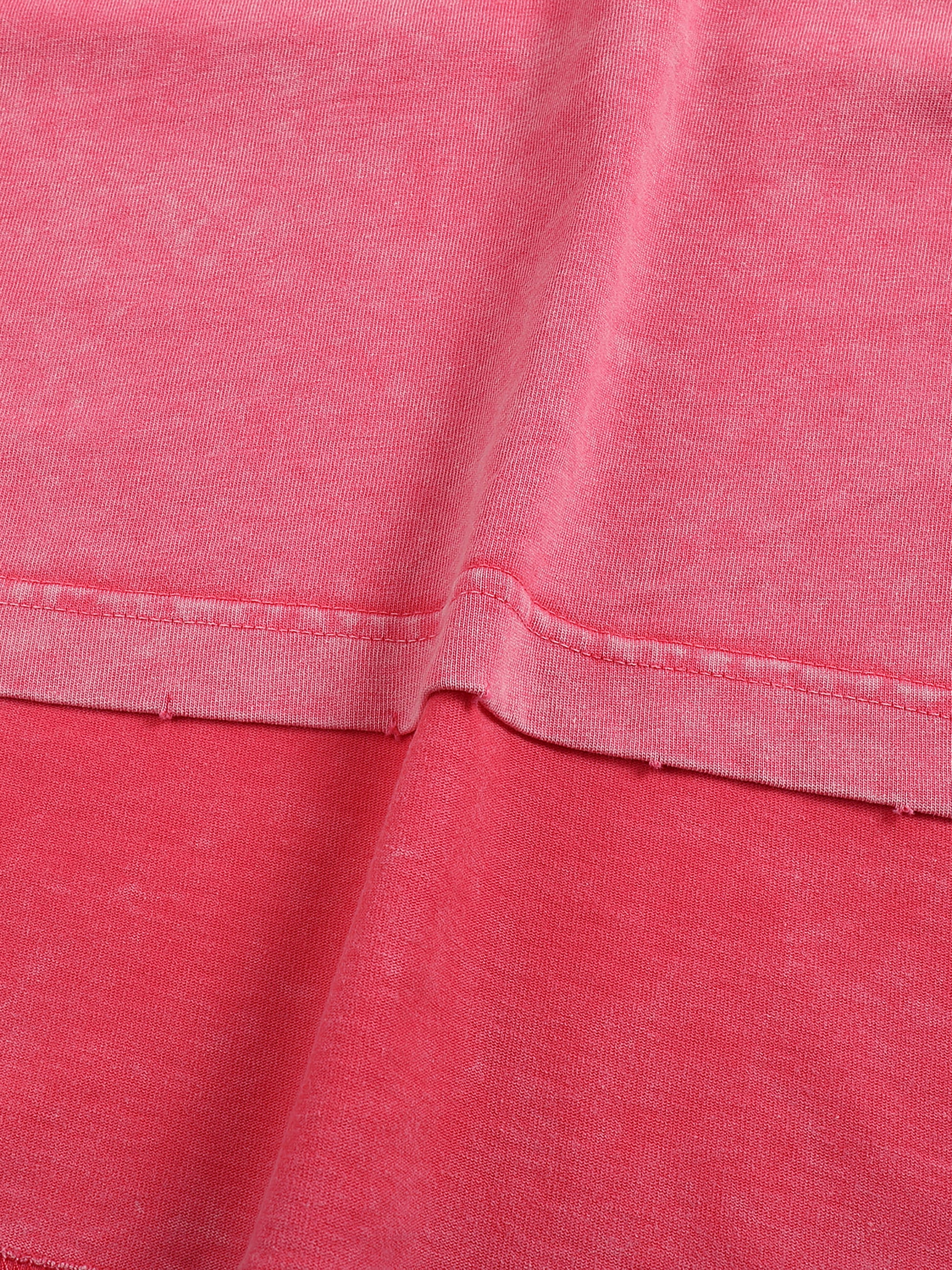 Close-up of pink fabric with a focus on texture and stitching.