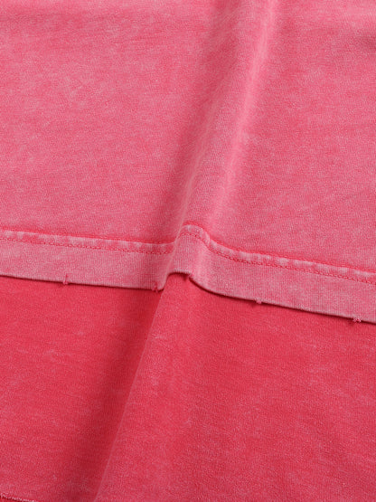 Close-up of pink fabric with a focus on texture and stitching.