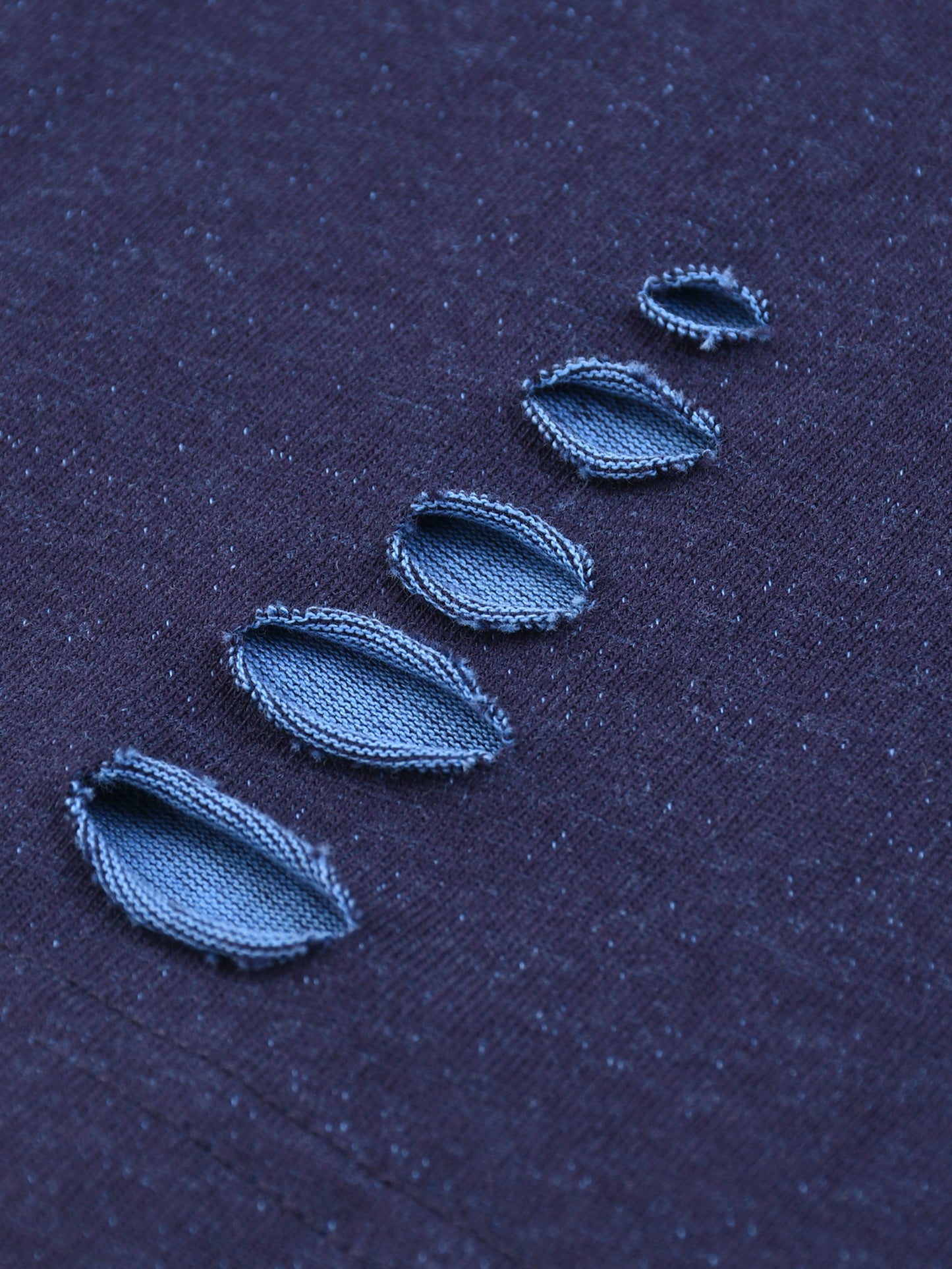 Close-up of blue embroidered leaves on a dark fabric background