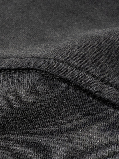 Close-up of dark gray fabric with a focus on texture and stitching.