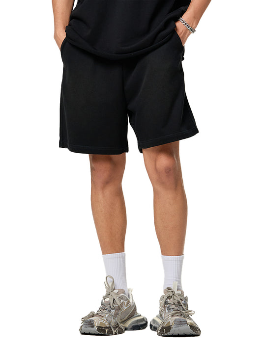 Person wearing black shorts and white sneakers on a white background
