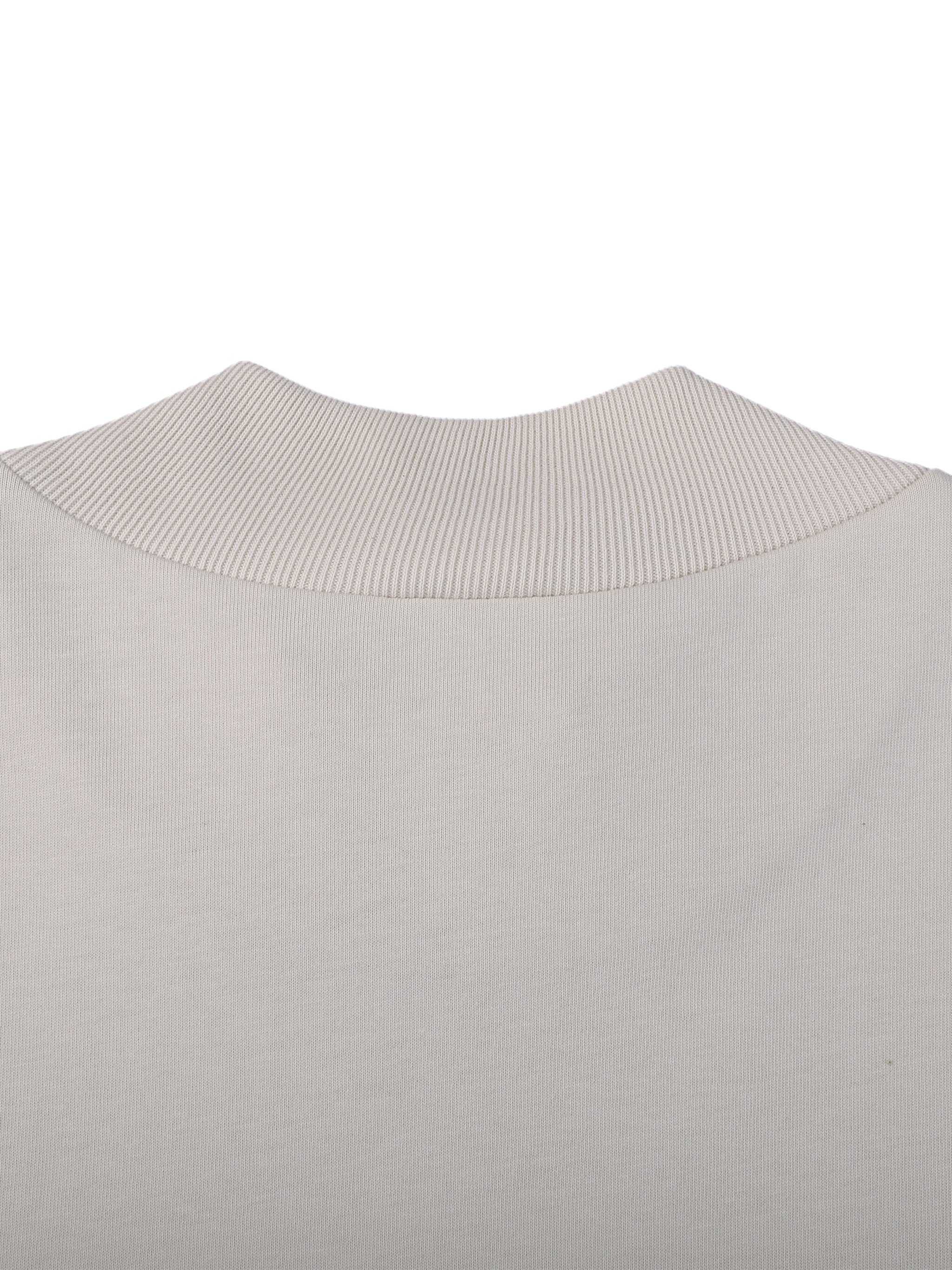 Close-up of a light gray sweater with a ribbed collar on a white background