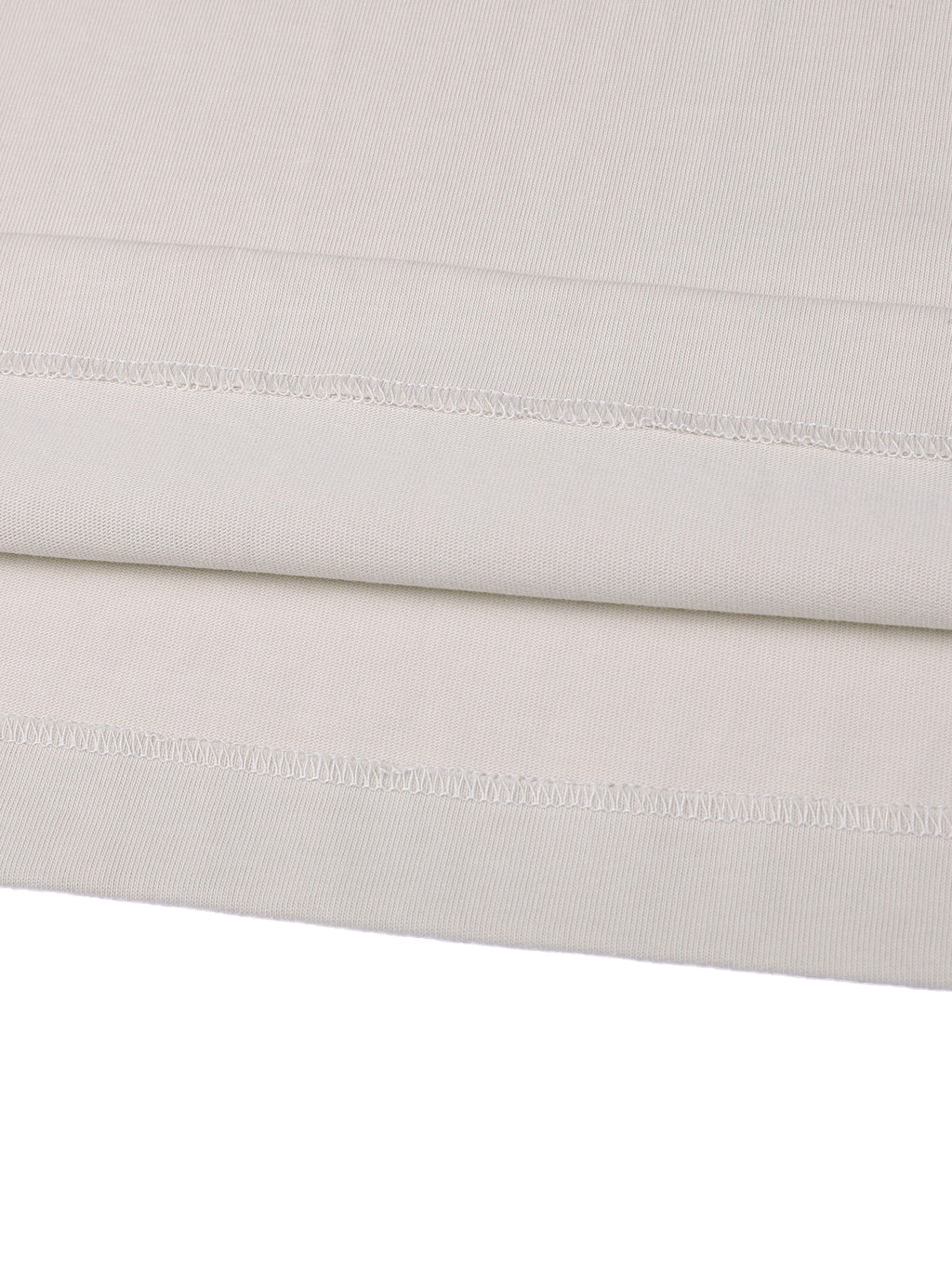 Close-up of a folded light gray fabric with visible stitching on a white background