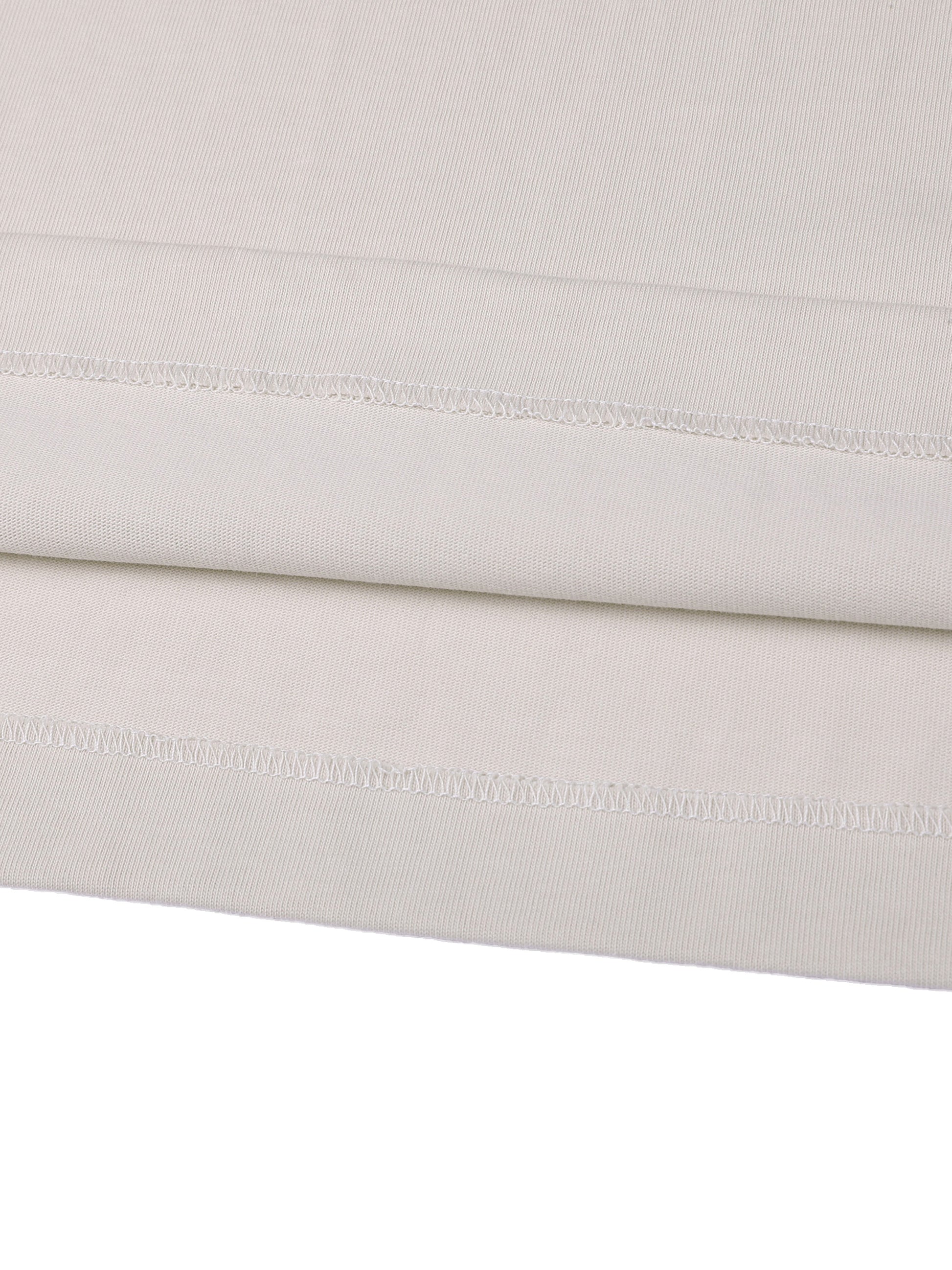 Close-up of a folded light gray fabric with visible stitching on a white background