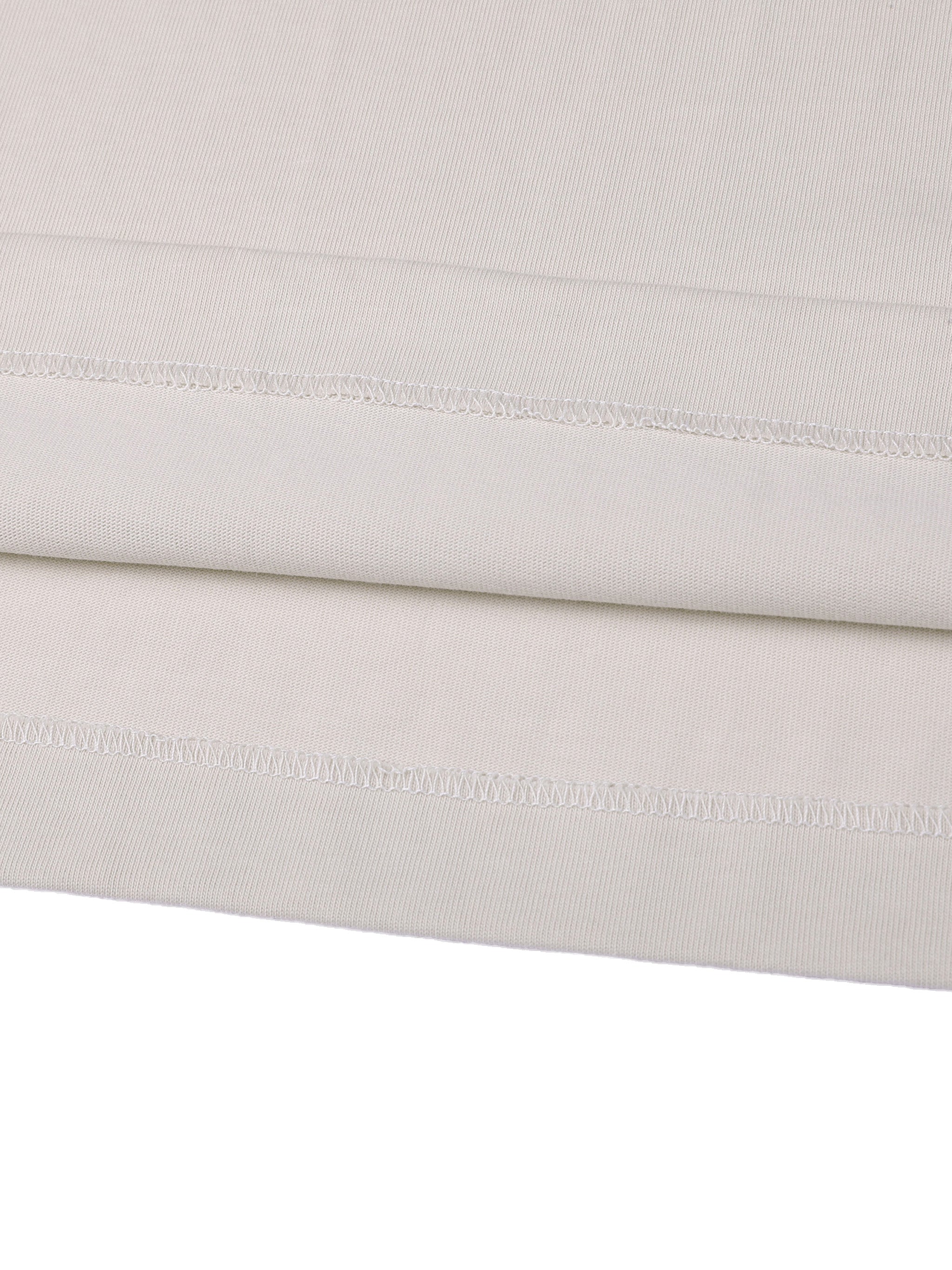 Close-up of a folded light gray fabric with visible stitching on a white background