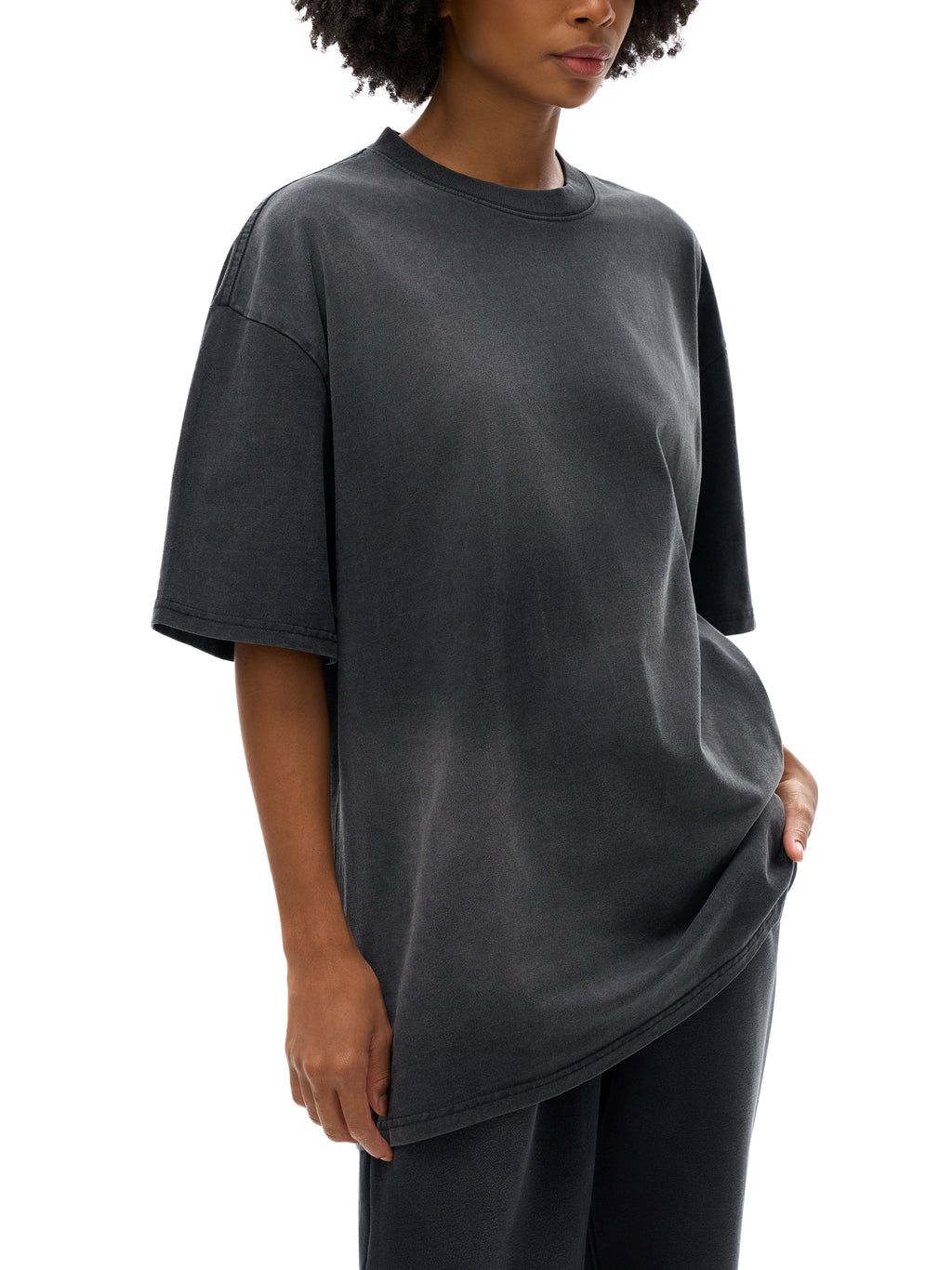 Person wearing a dark gray oversized t-shirt on a white background