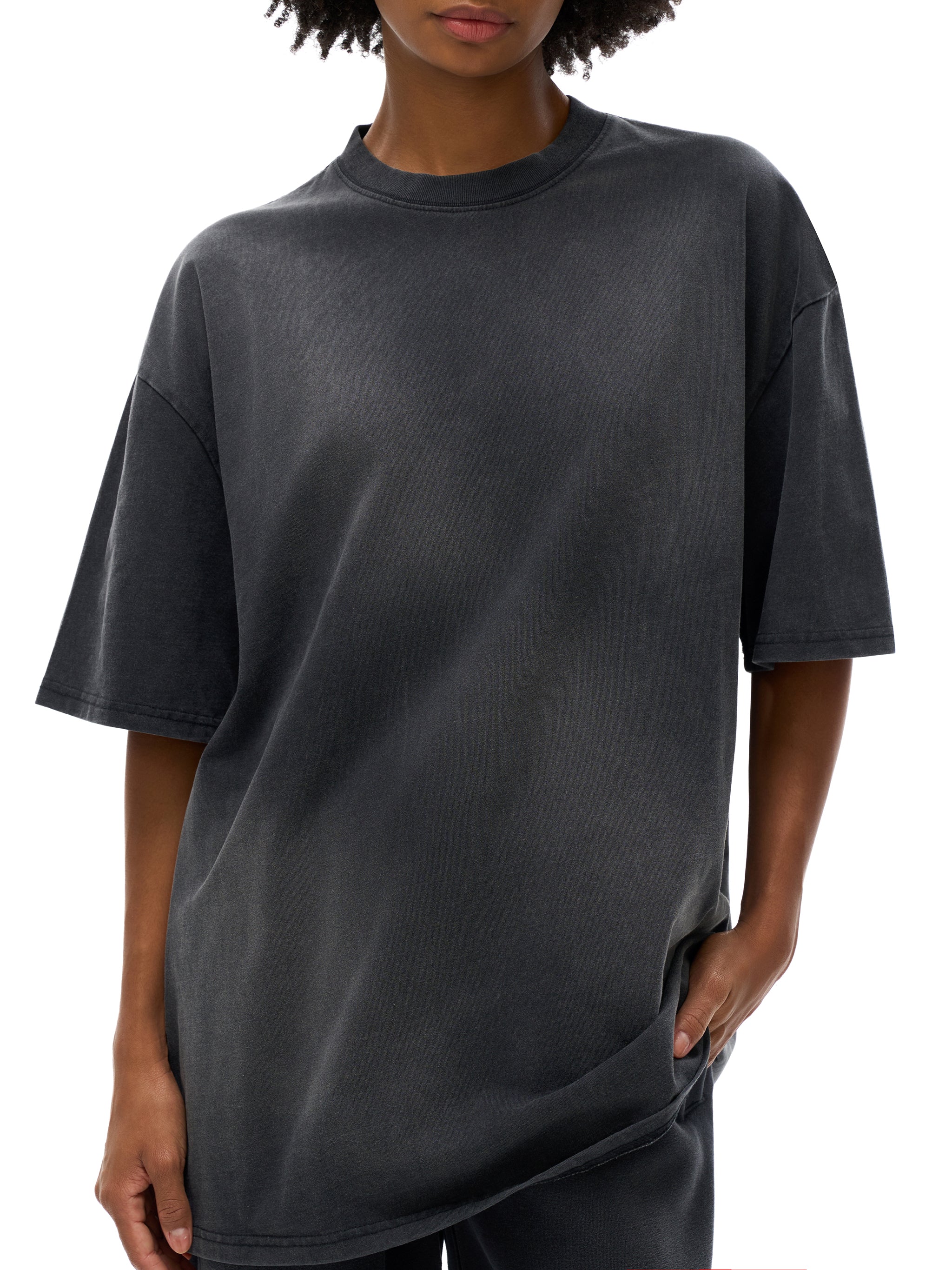 Person wearing a plain black t-shirt on a white background
