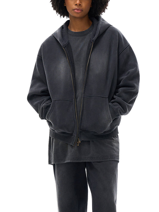 Person wearing a dark gray hoodie and pants on a white background