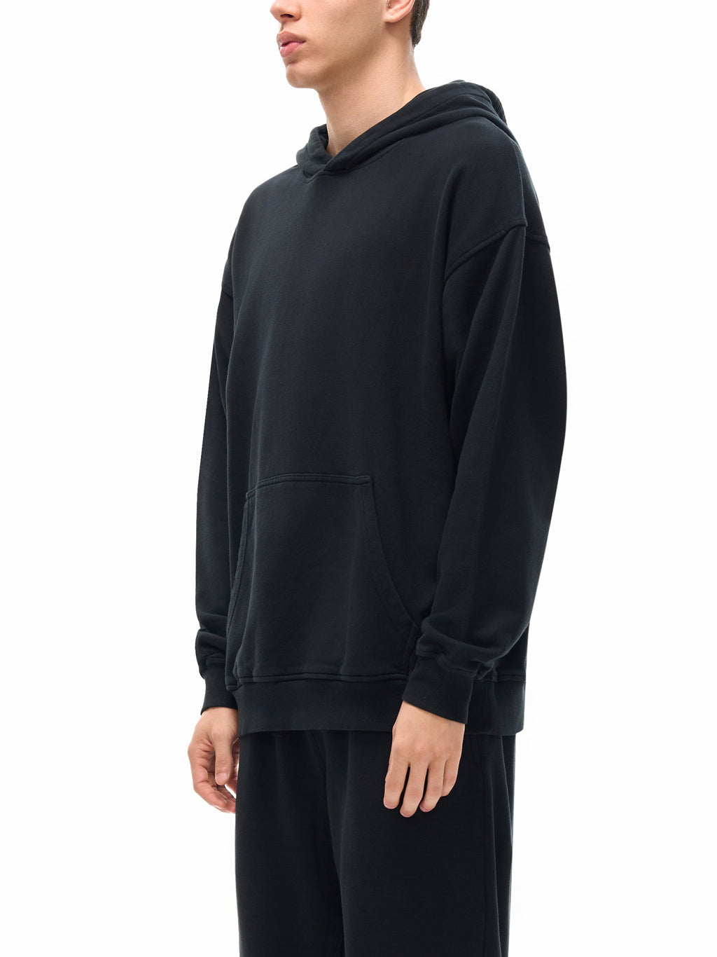 Person wearing a black hoodie on a white background