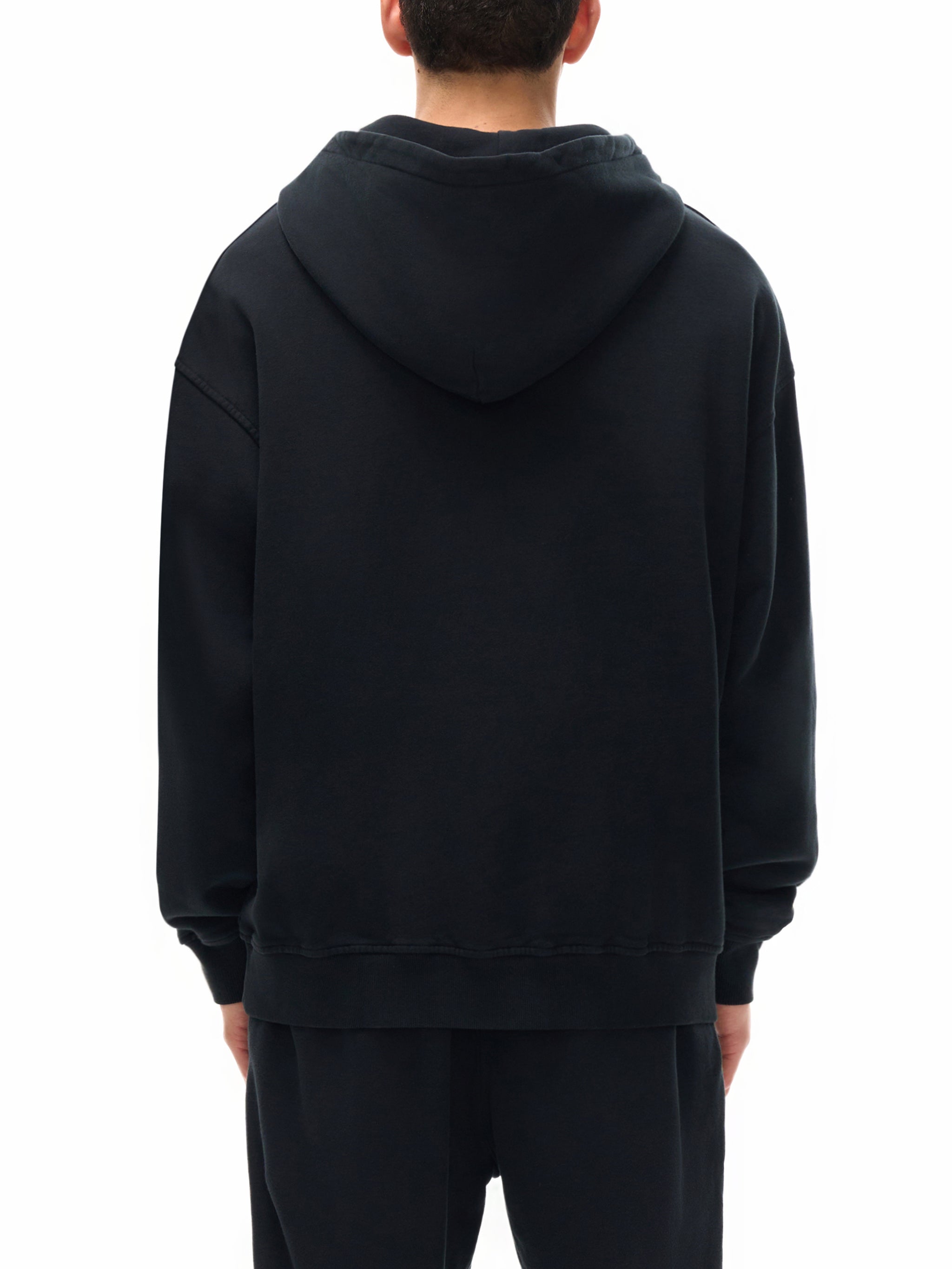 Person wearing a black hoodie from behind on a white background
