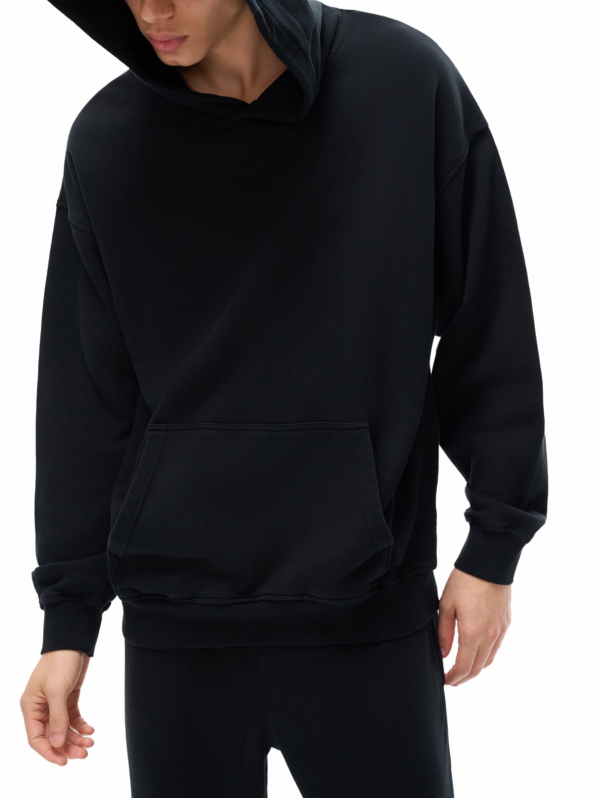 Black hoodie worn by a person on a white background