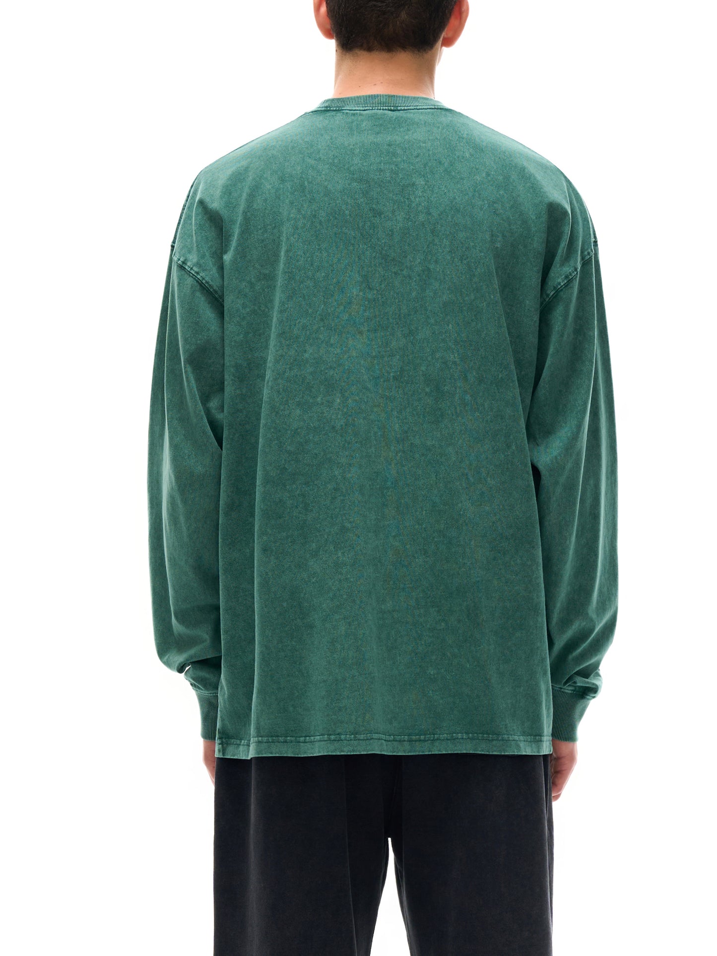 Person wearing a green long-sleeve shirt on a white background