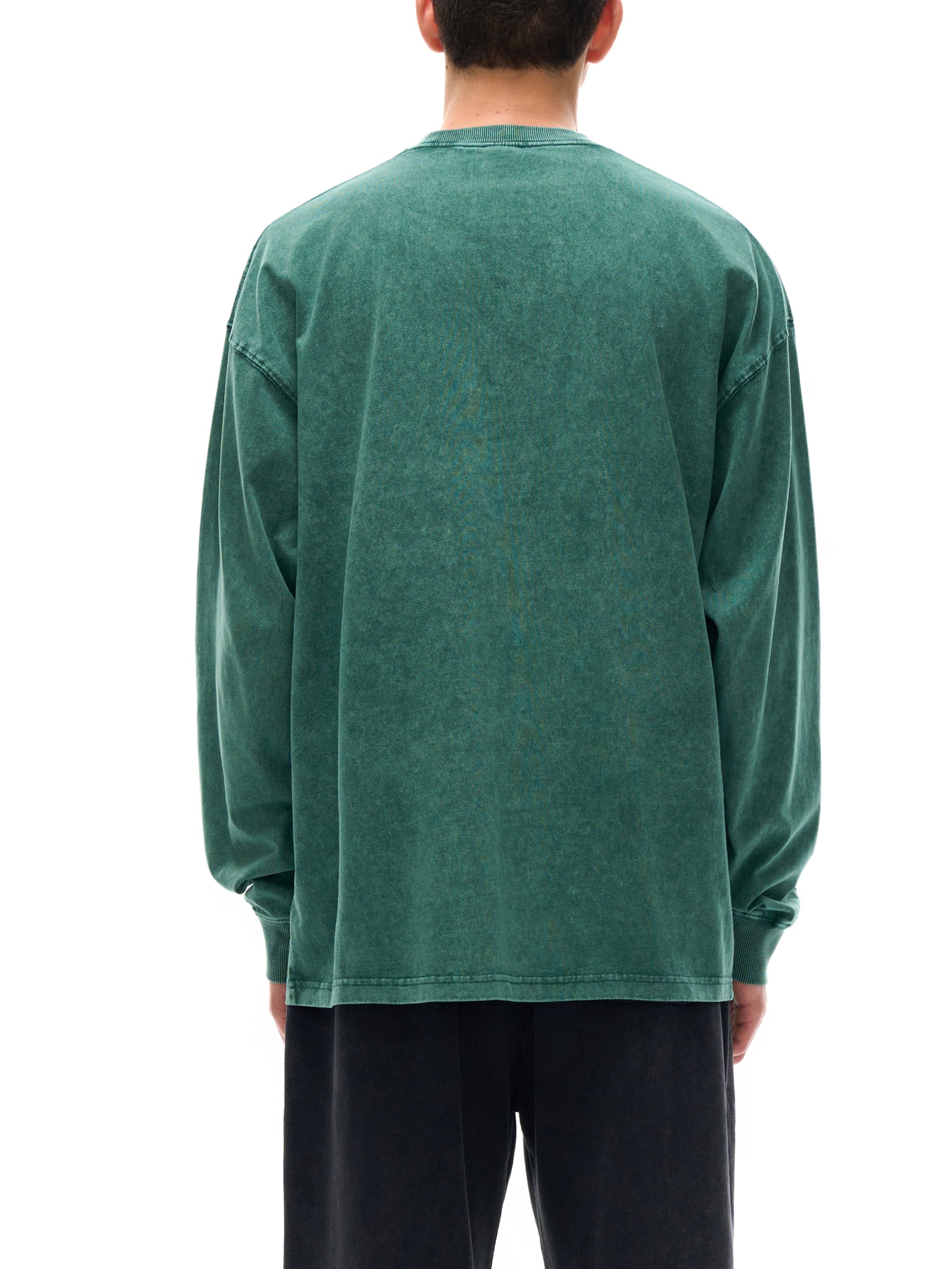 Person wearing a green long-sleeve shirt on a white background