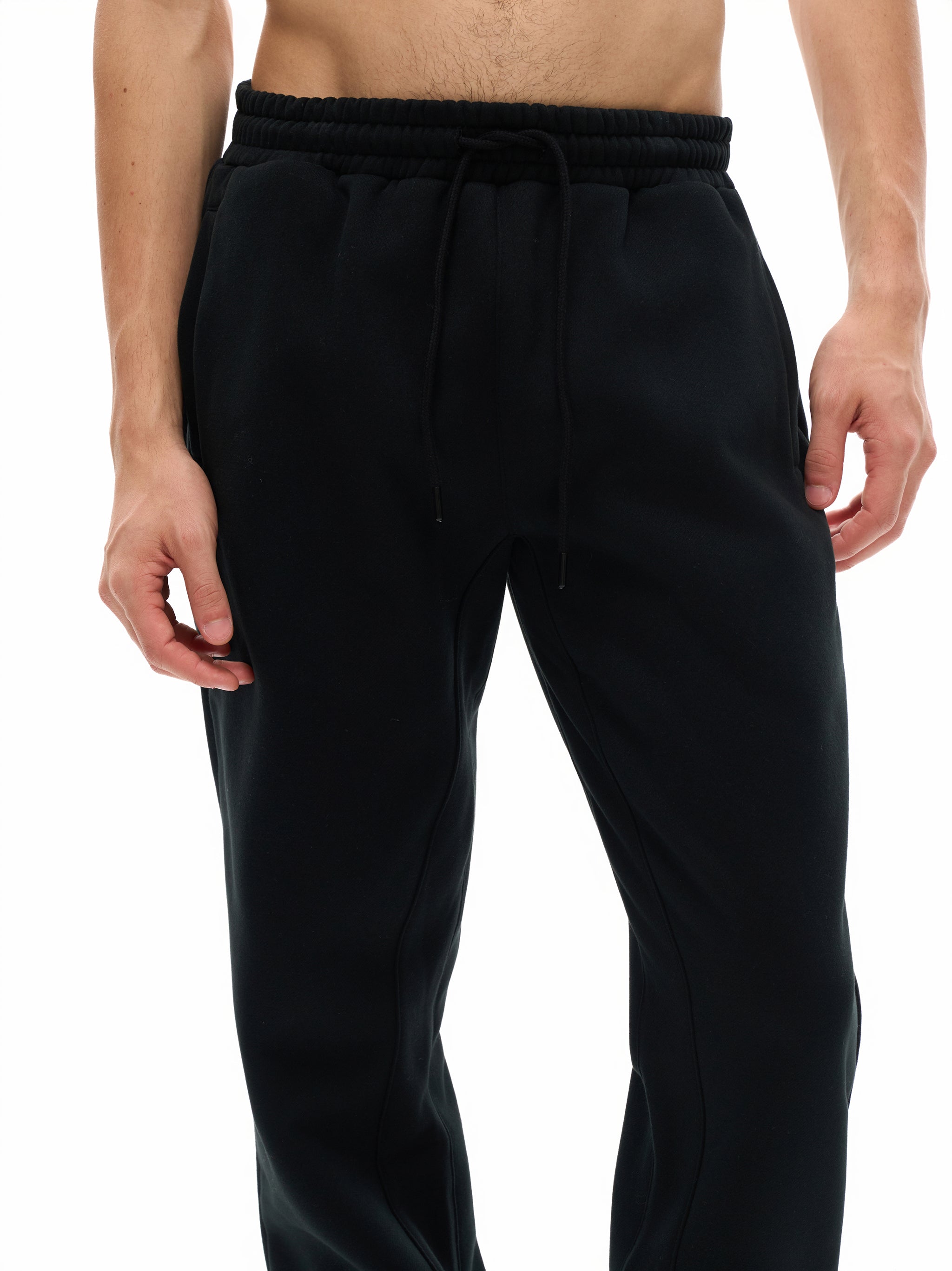 Black pants worn by a person on a white background
