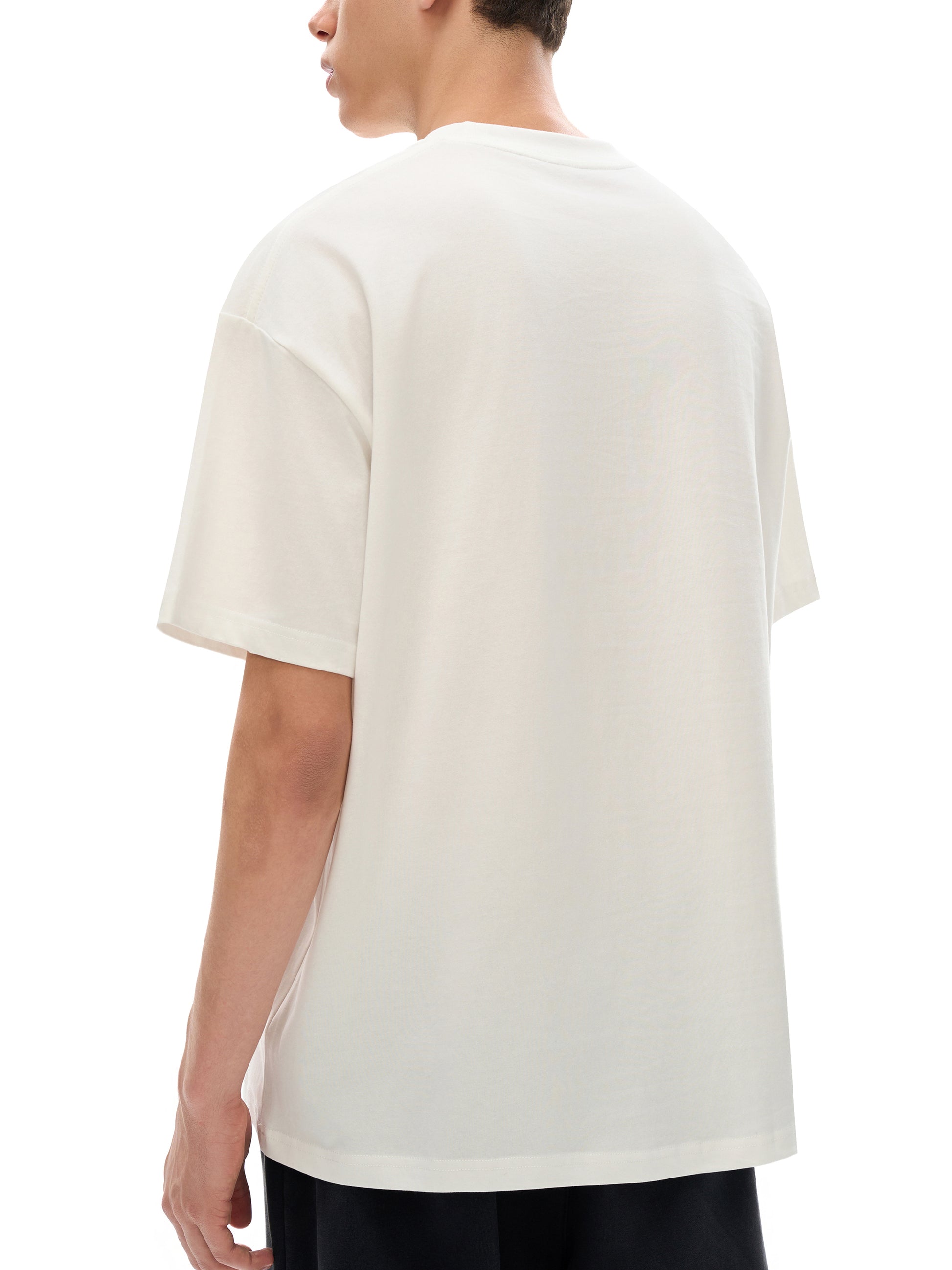 Person wearing a plain white t-shirt on a white background