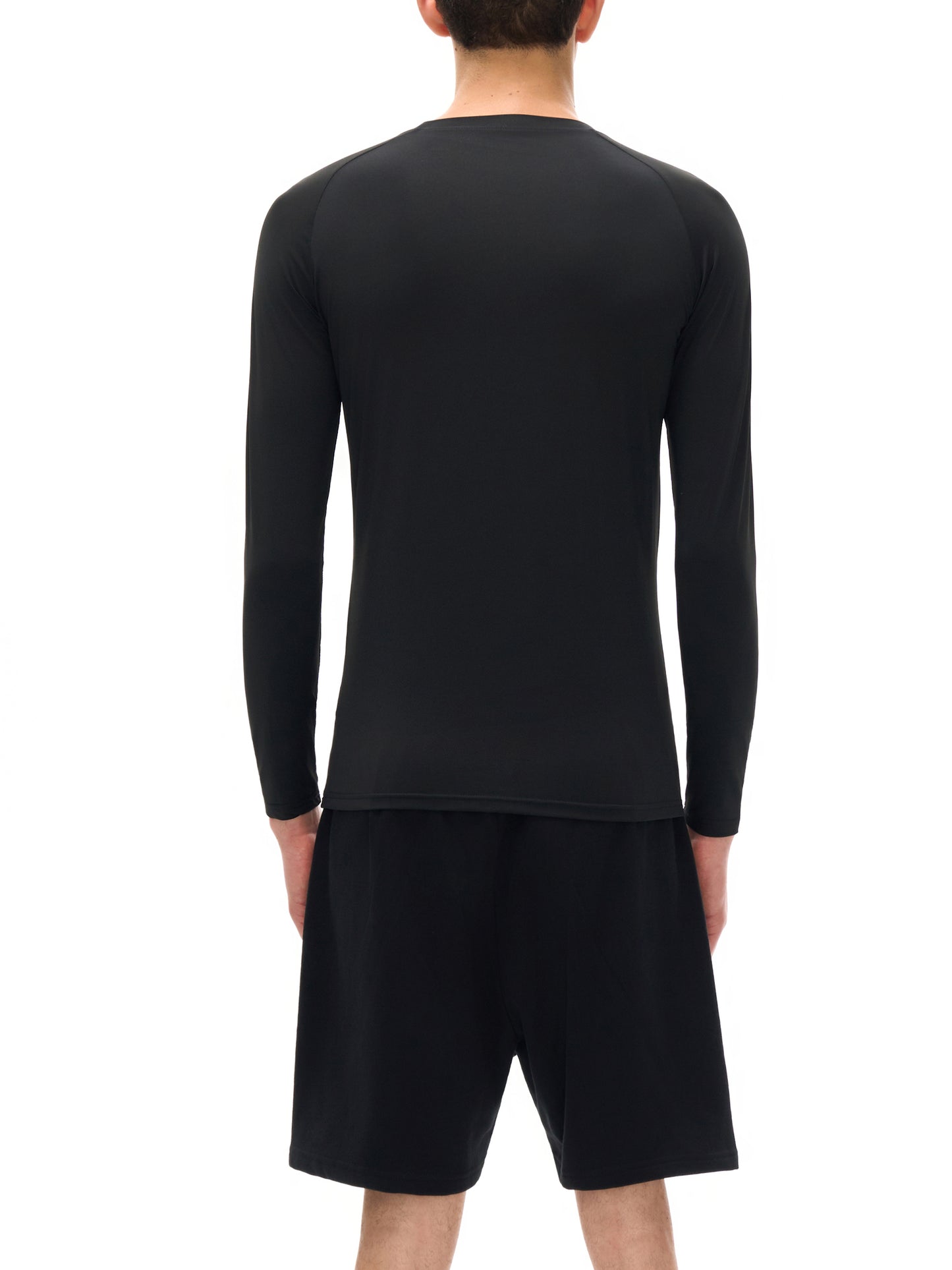 Person wearing a black long-sleeve shirt and shorts on a white background