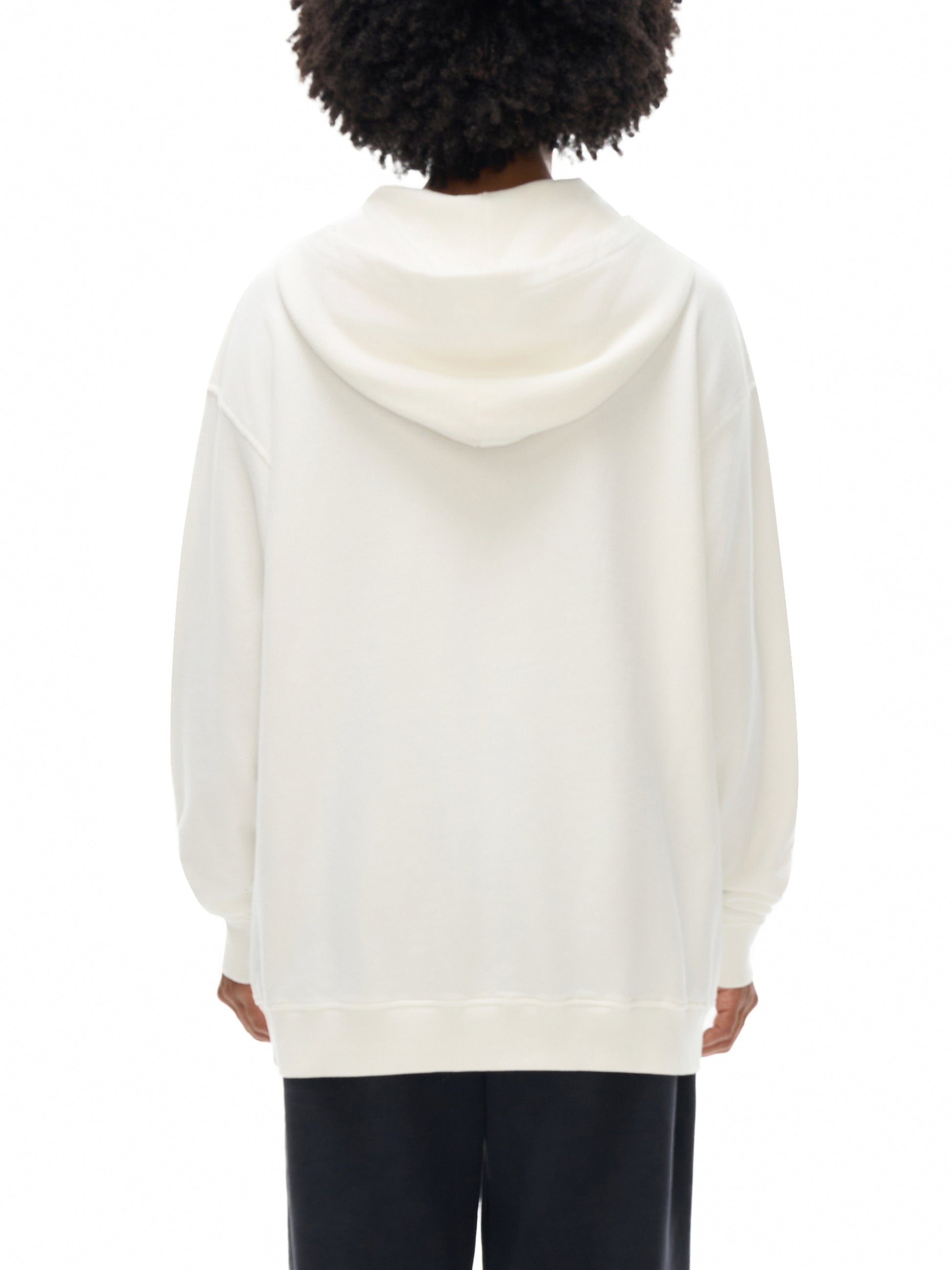Person wearing a white hoodie from behind on a white background