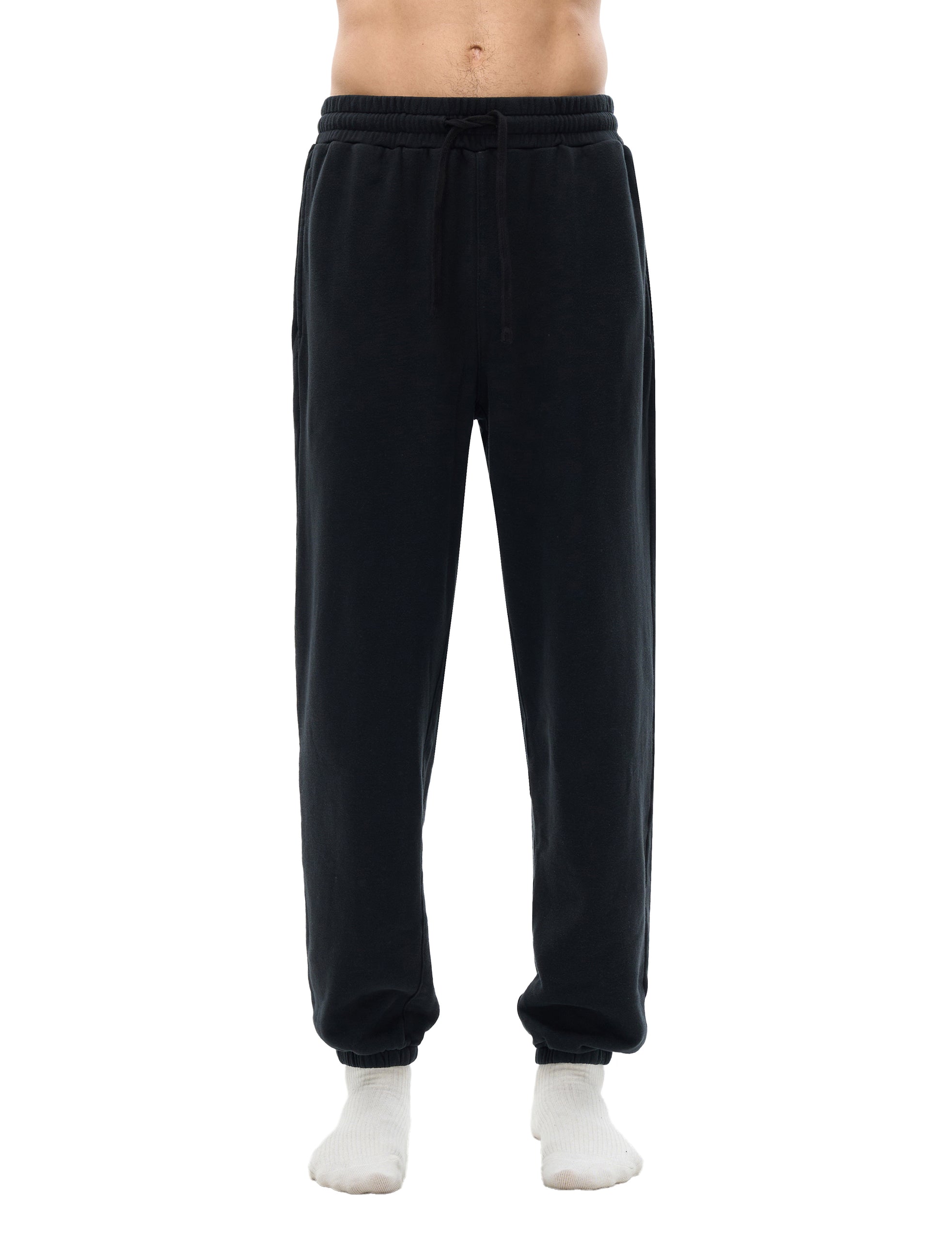 Black sweatpants worn by a person on a white background
