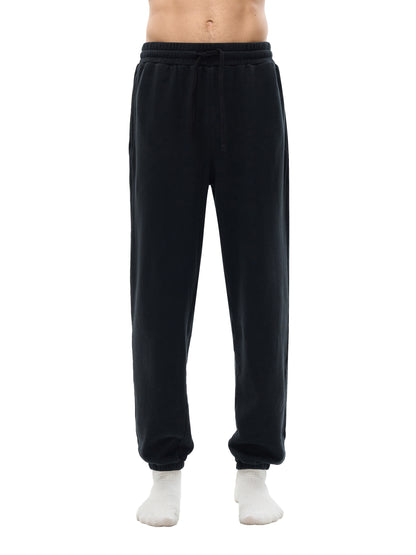 Black sweatpants worn by a person on a white background