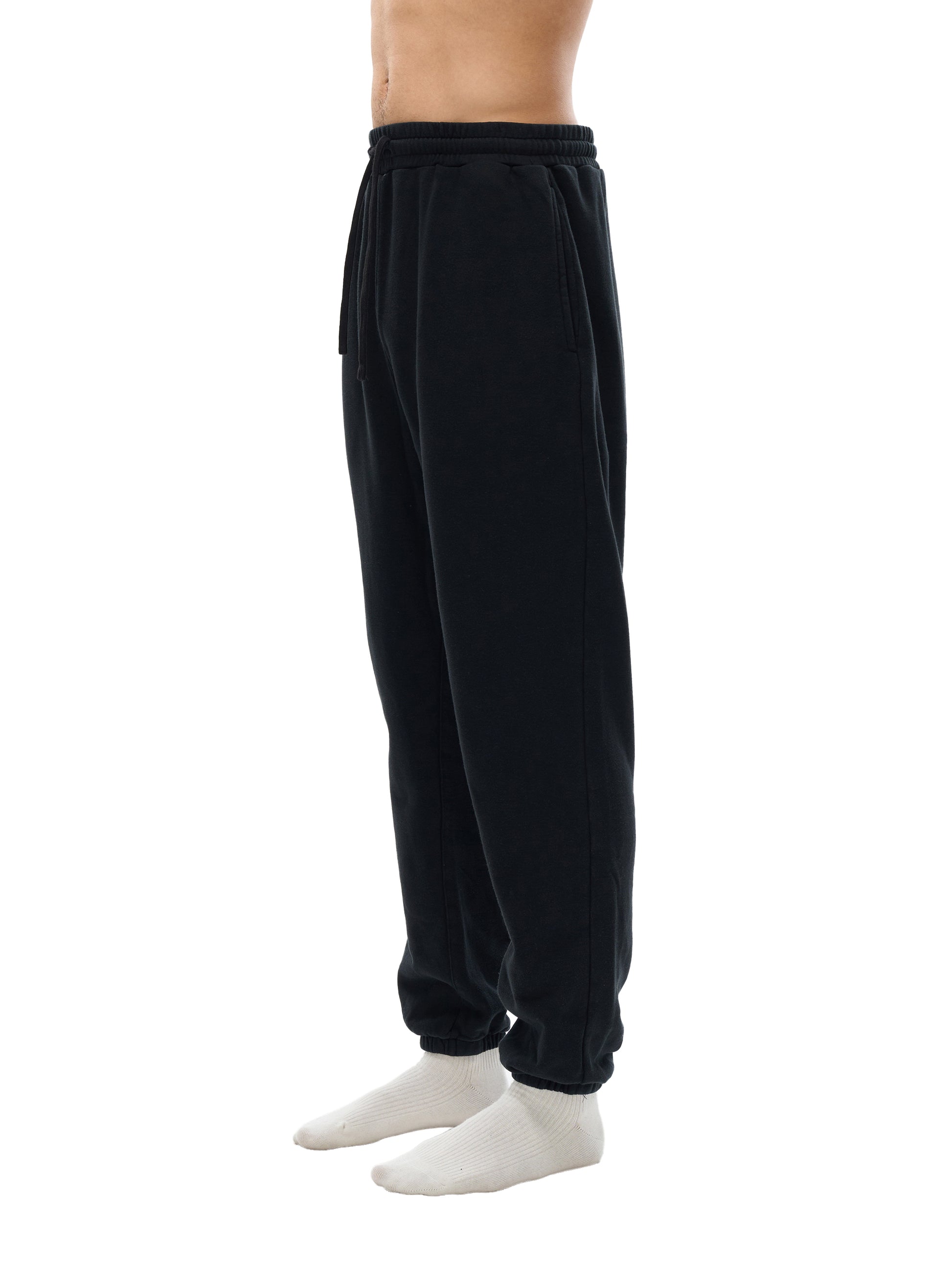 Black sweatpants worn by a person on a white background