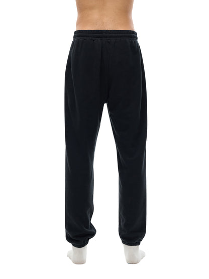 Black sweatpants worn by a person on a white background