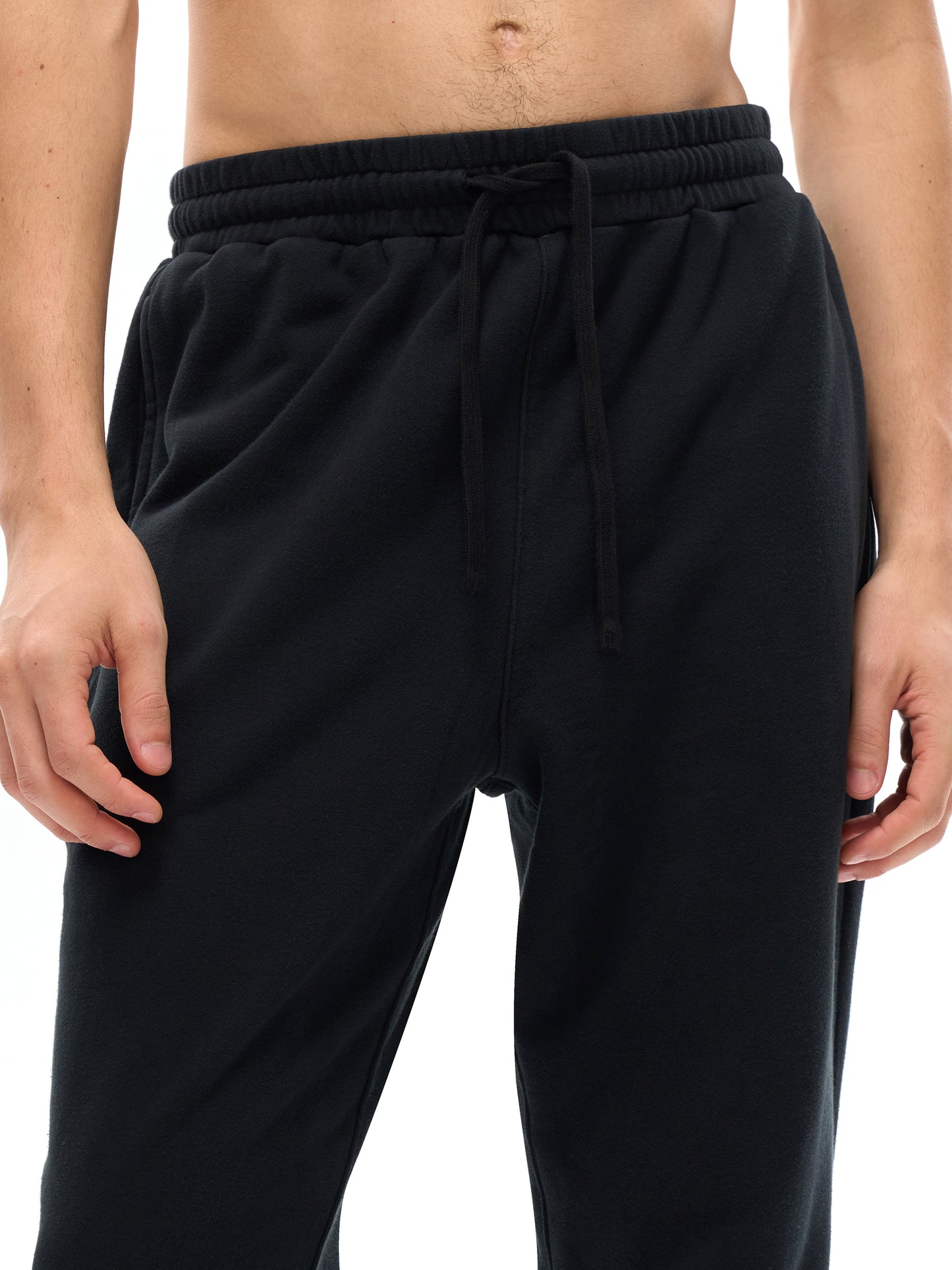 Black jogger pants worn by a person on a white background