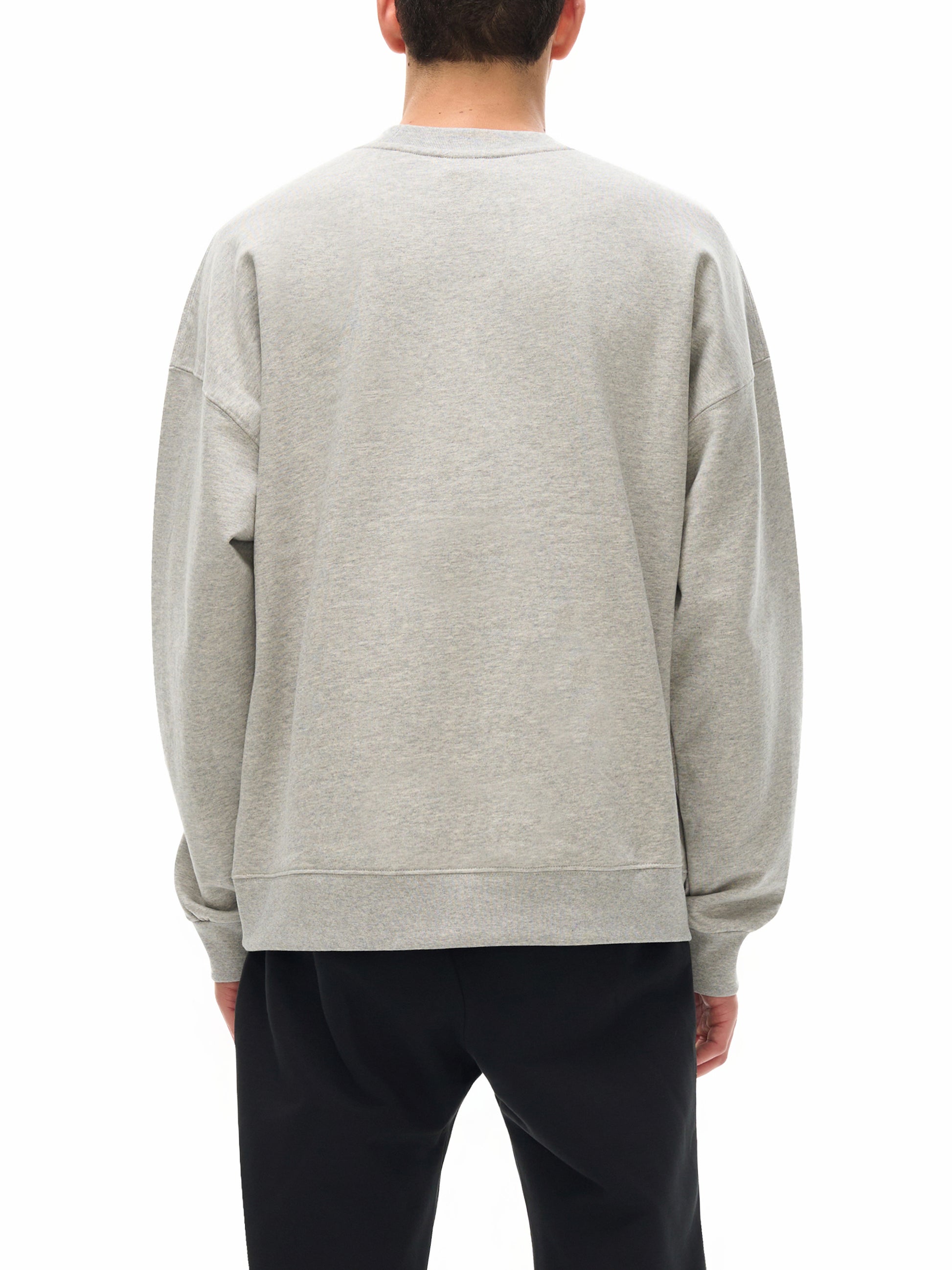Person wearing a gray sweatshirt from behind on a white background