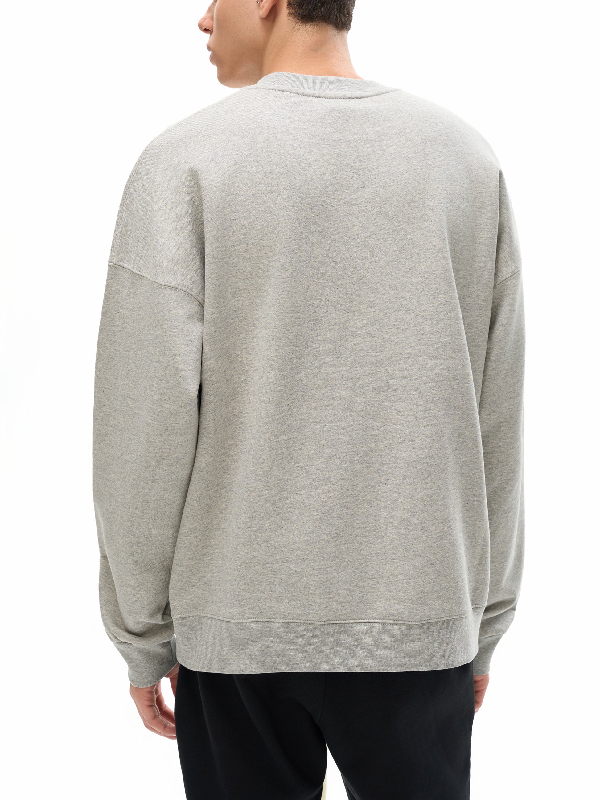 Person wearing a gray sweatshirt on a white background