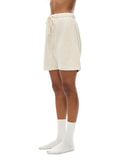 VERON Person wearing cream shorts and white socks on a white background