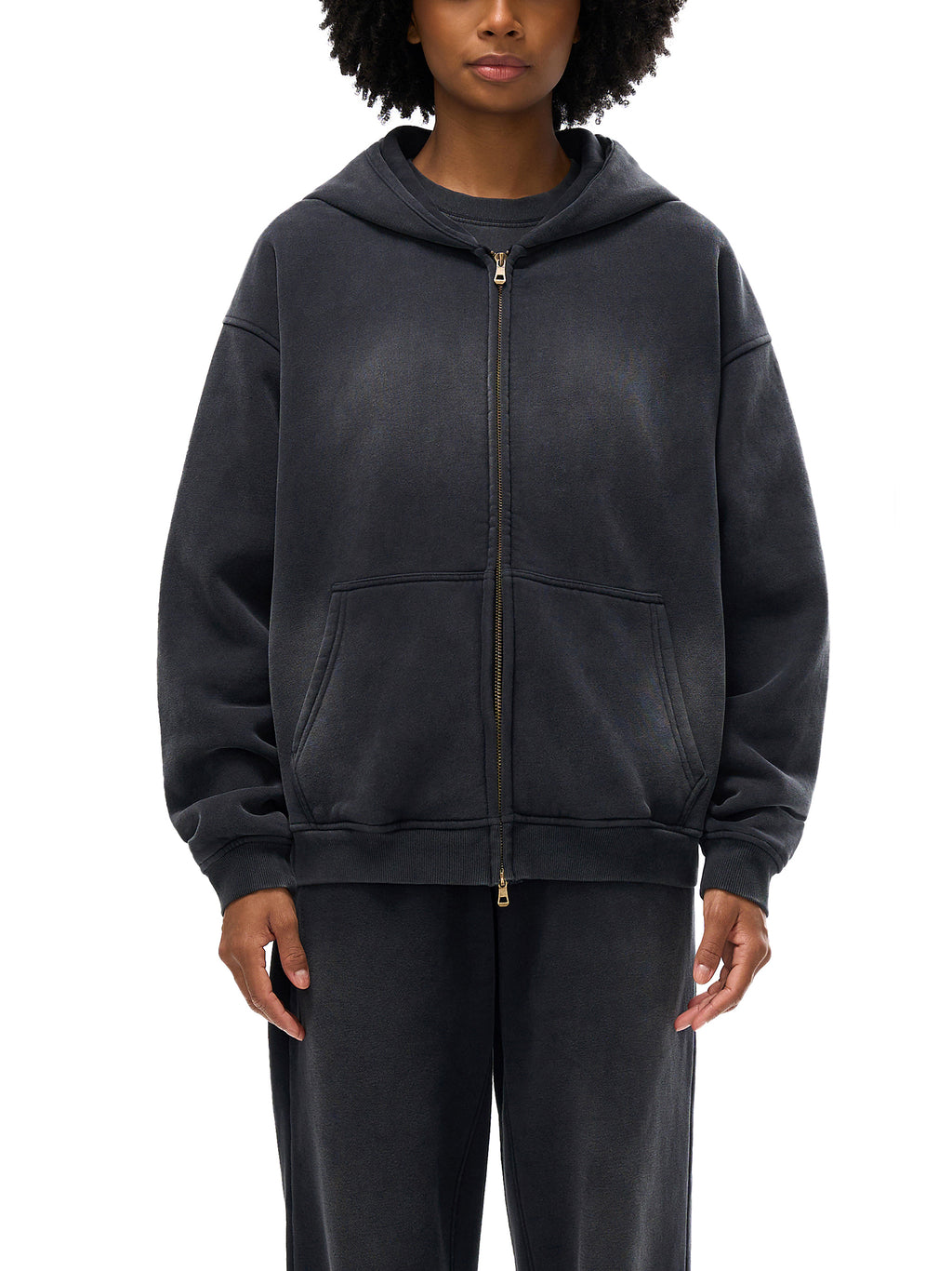 Person wearing a black zip-up hoodie on a white background