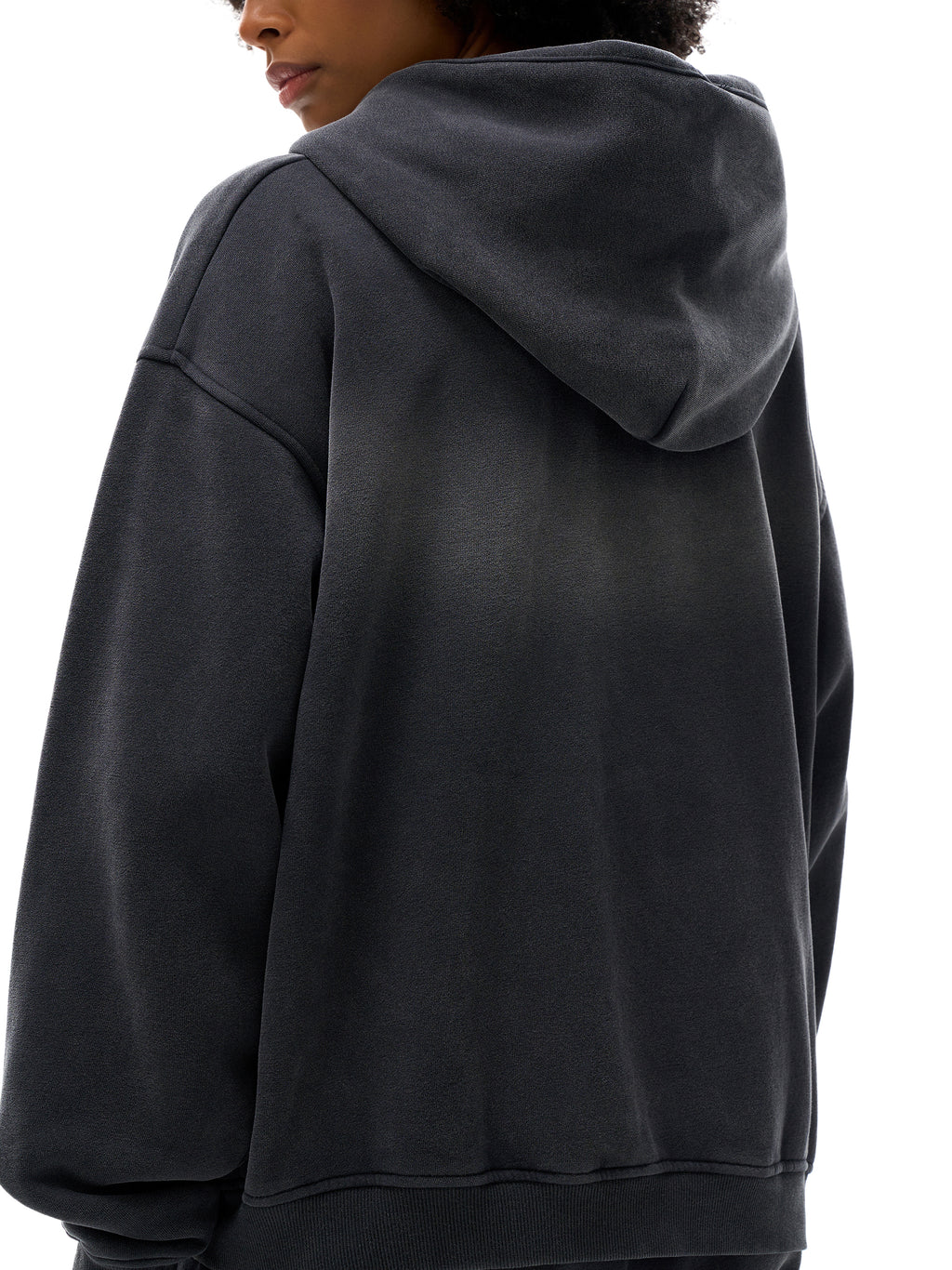 Person wearing a black hoodie from behind on a white background