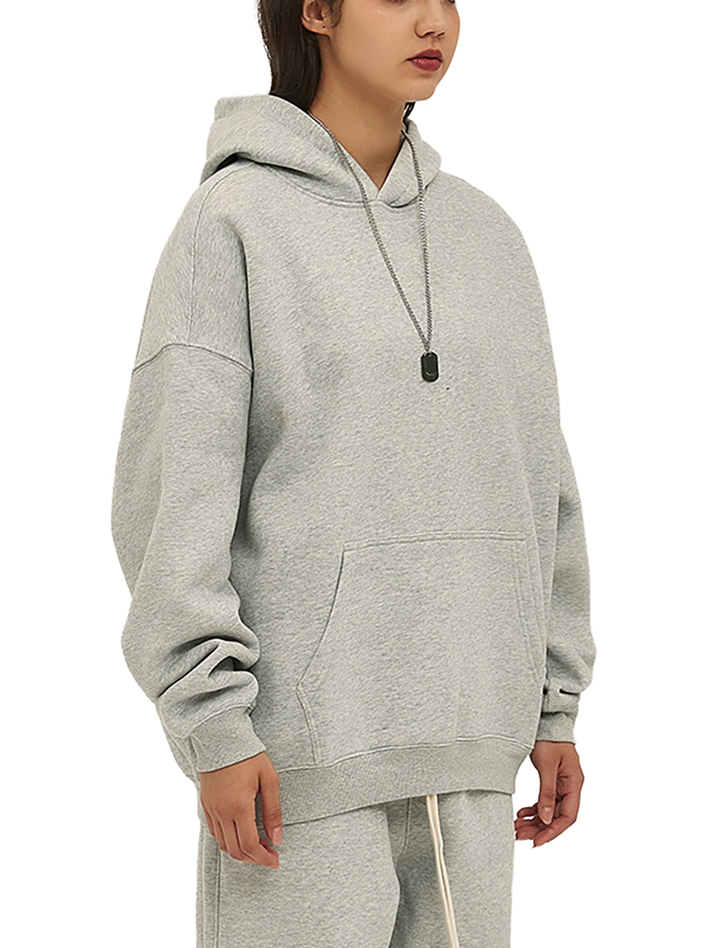 Person wearing a gray hoodie and pants on a white background