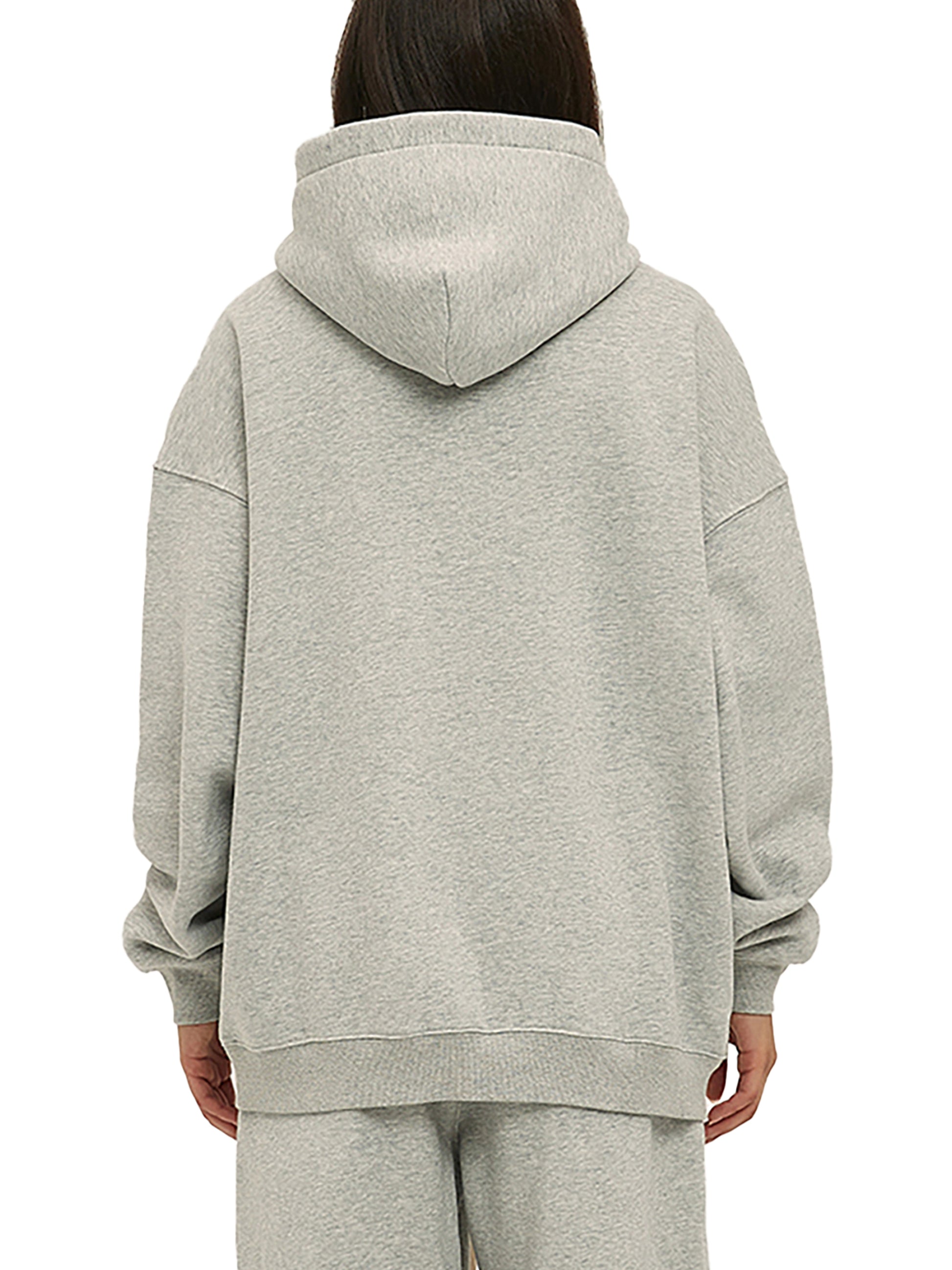 Person wearing a gray hoodie and pants on a white background