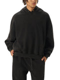Person wearing a black hoodie and pants on a white background