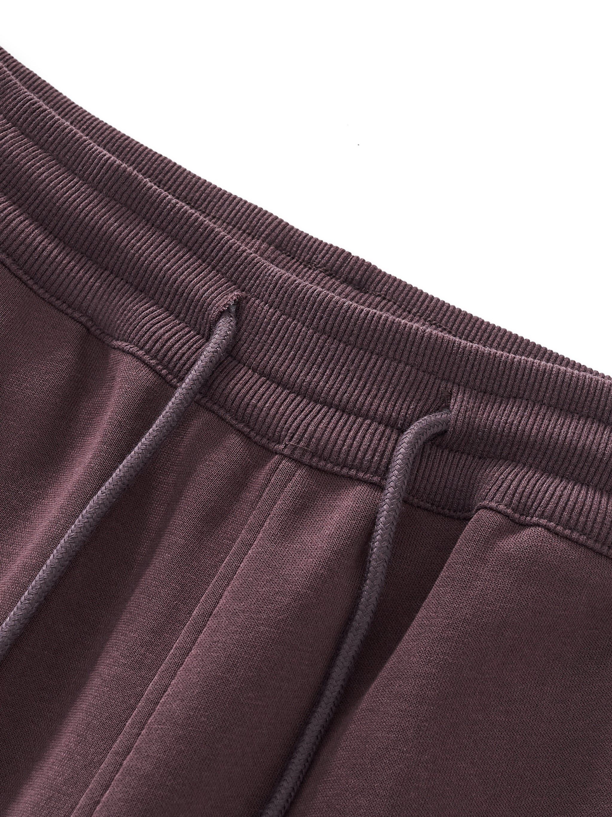 Close-up of brown sweatpants with drawstring on a white background